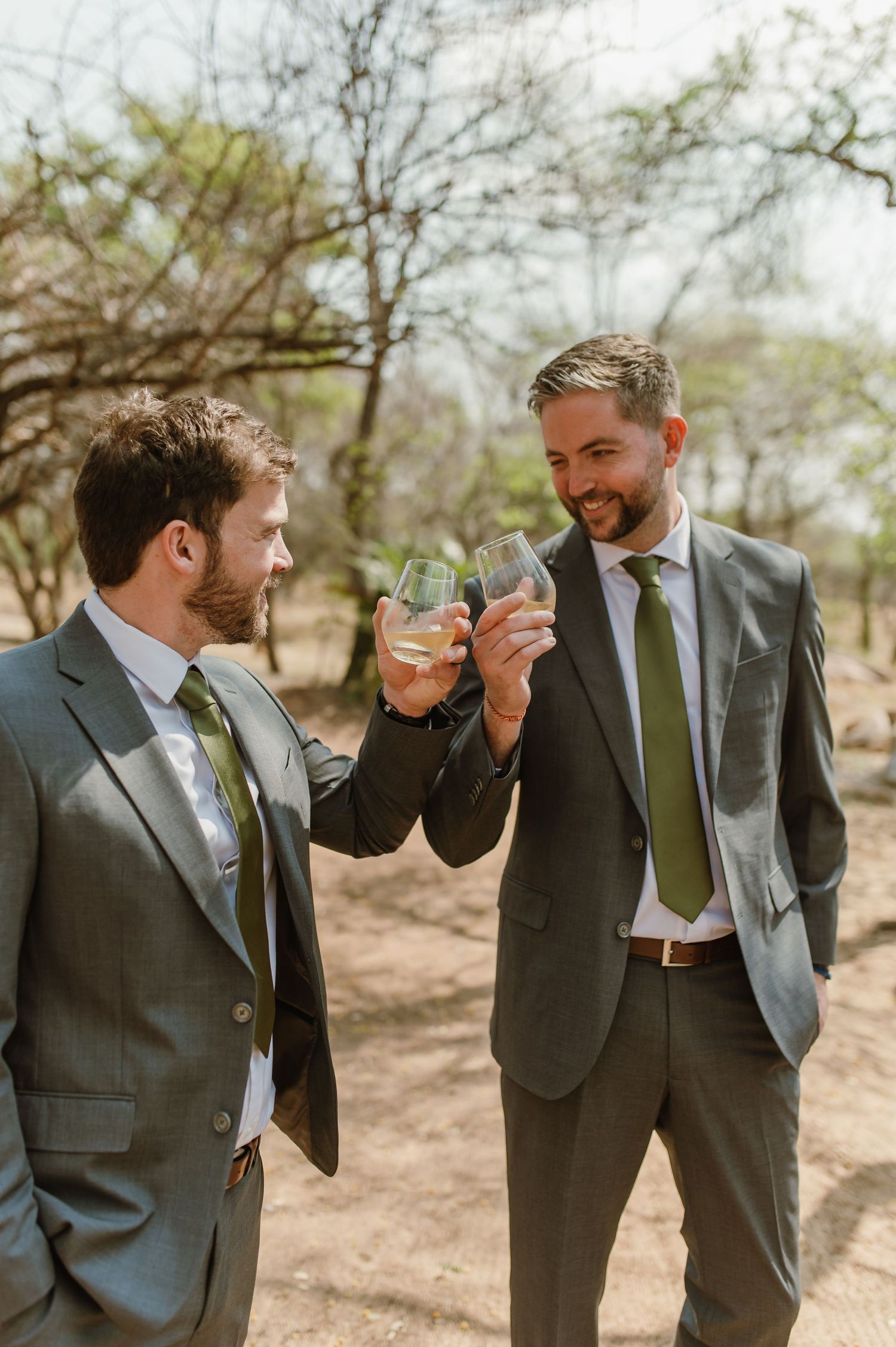 Groomsmen reacting after taking shots of alcohol outdoors.