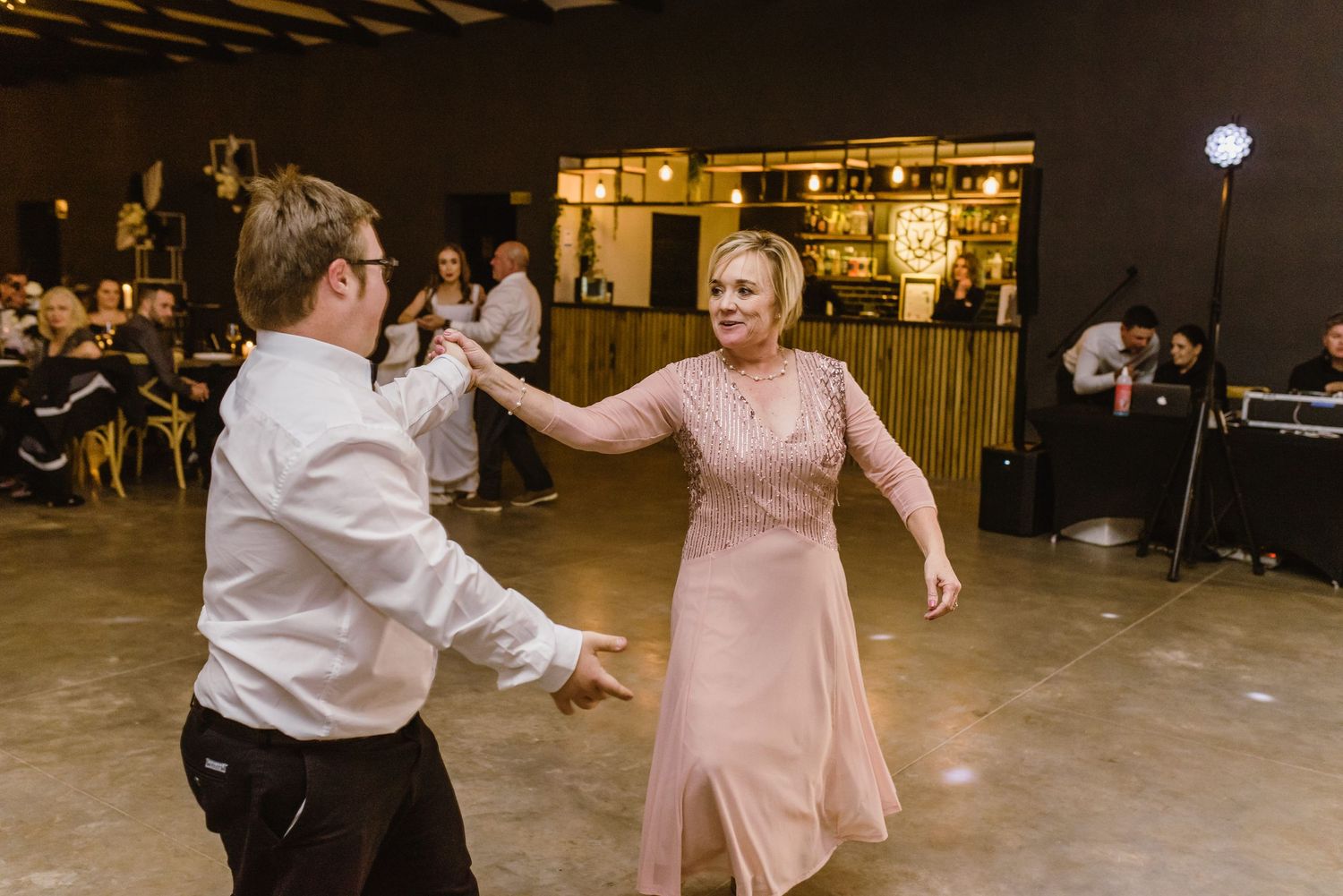 Dancers twirling in a dimly lit indoor space during a celebration event.