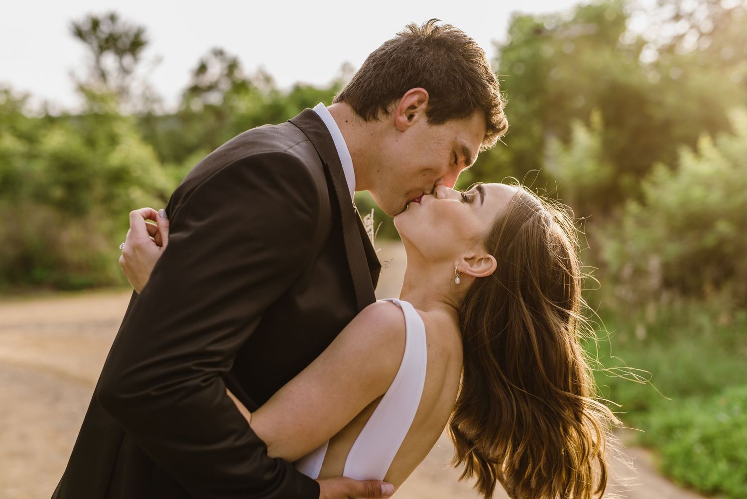 A series of romantic dance poses between newlyweds on a natural path.