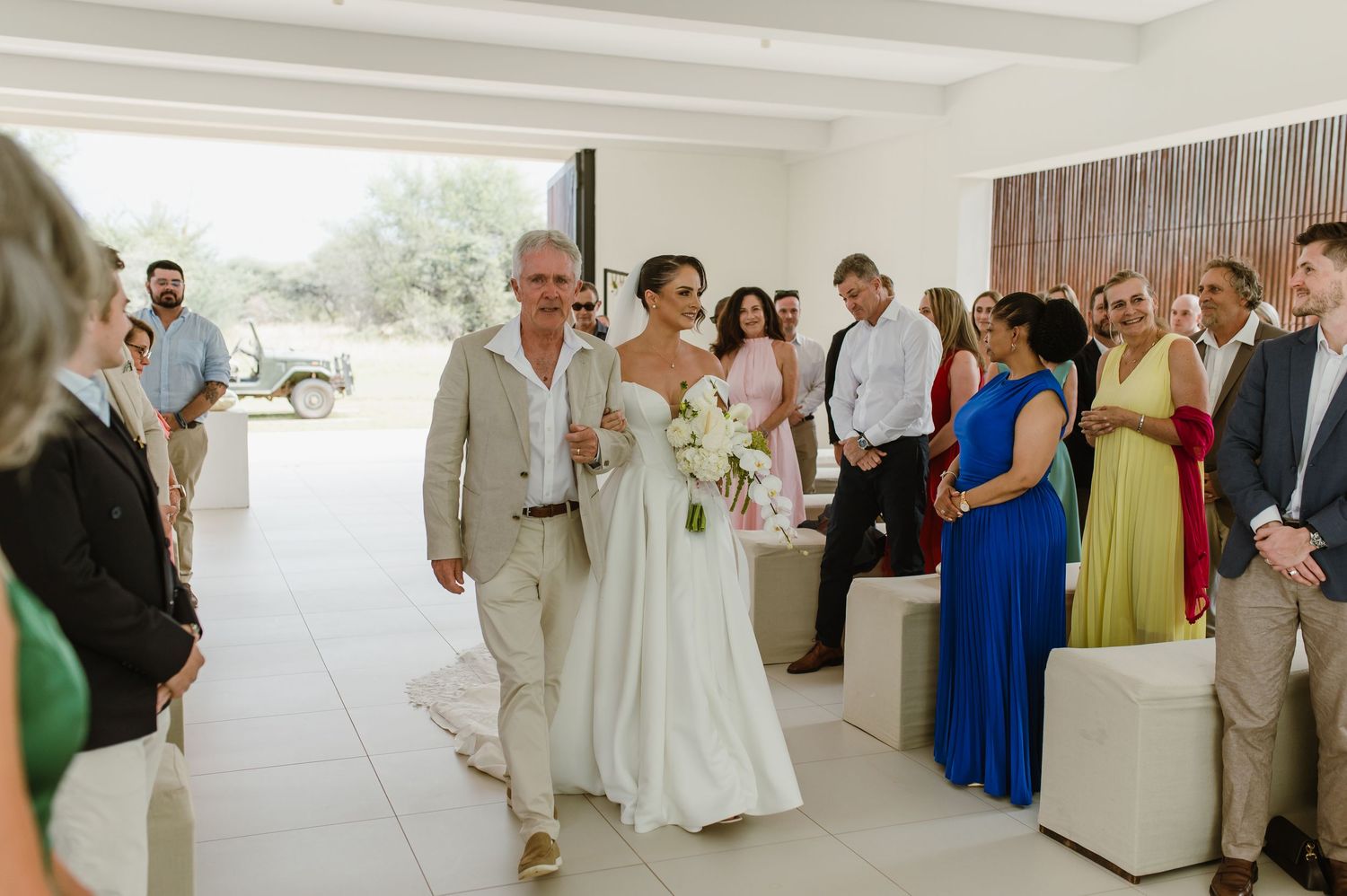 Wedding reception in a contemporary white space with guests mingling and celebrating.