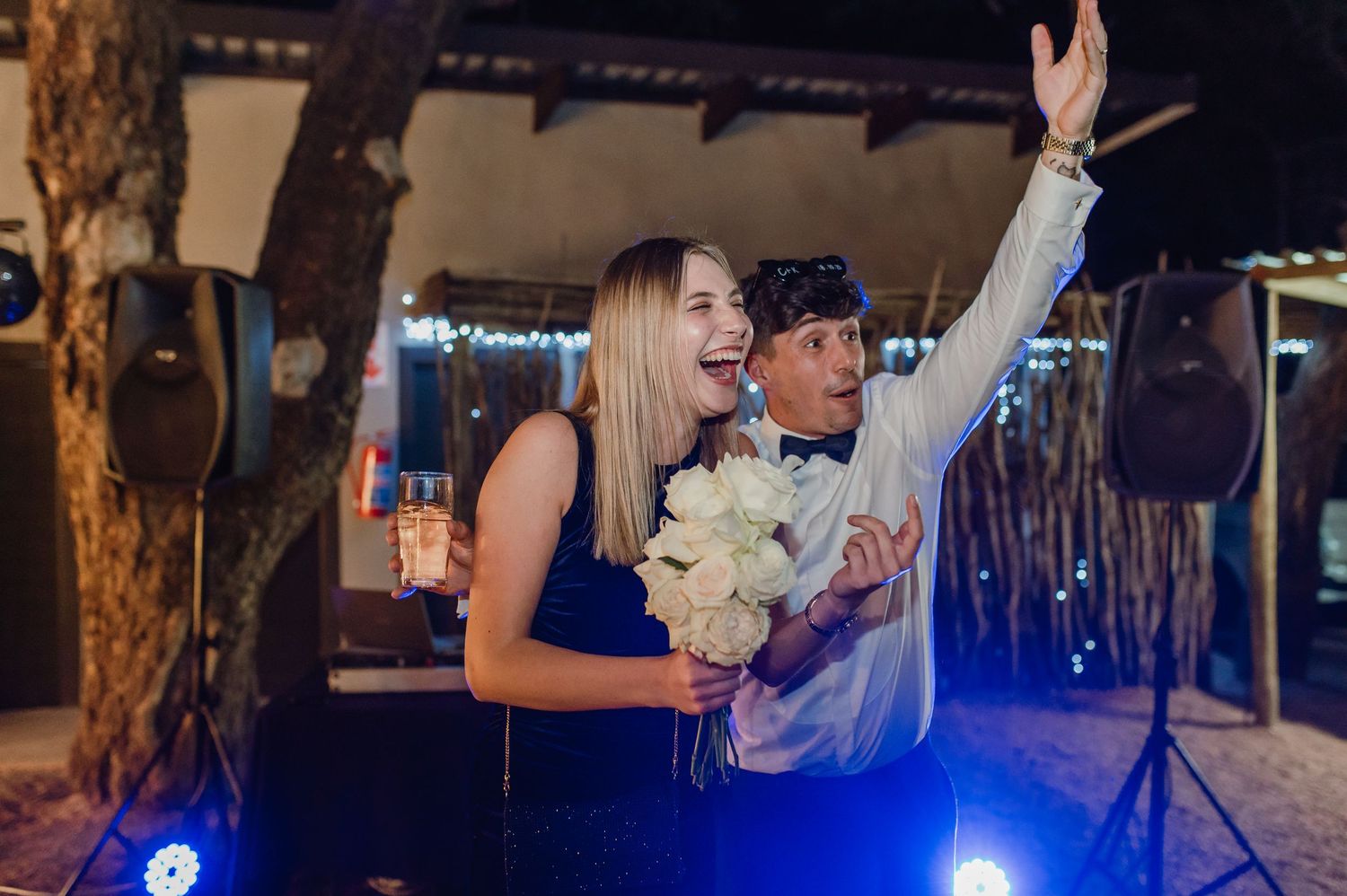 Celebratory evening event with people dancing under blue and warm lighting.