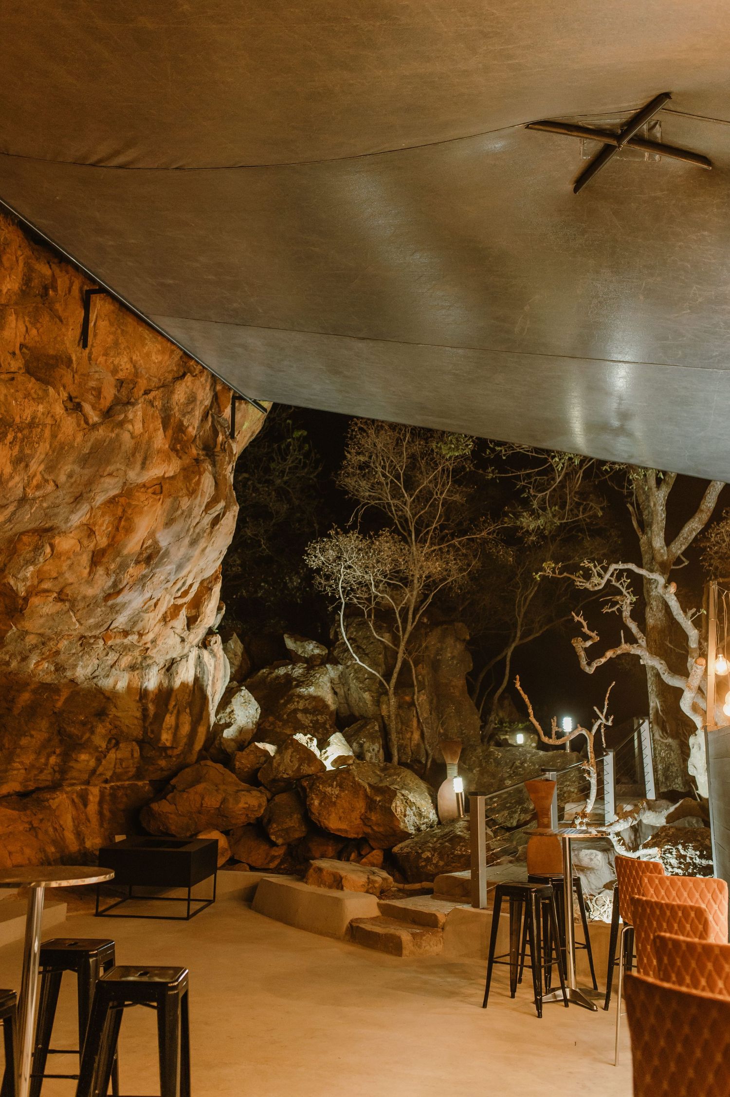 Atmospheric cave bar setup with vintage furniture and mood lighting.