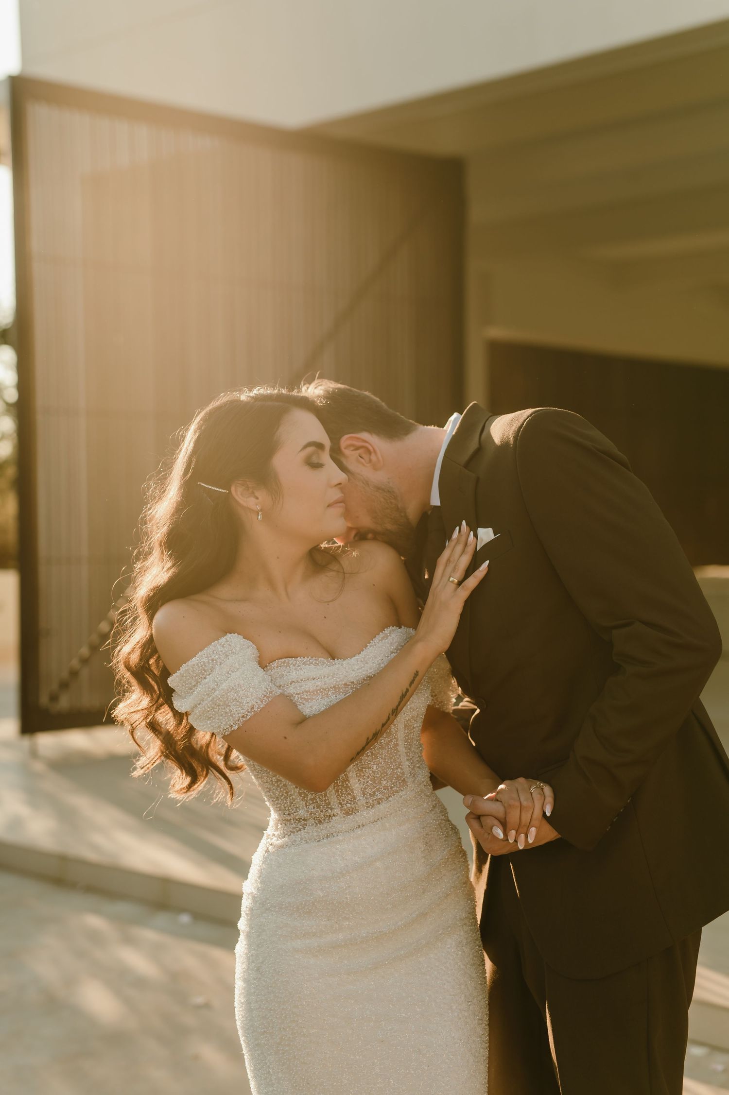 Newlyweds embrace in a series of candid moments during sunset.