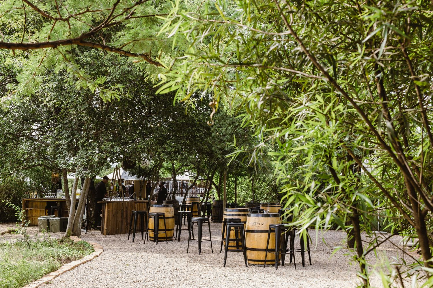 Outdoor wedding venue path lined with trees and natural landscaping.