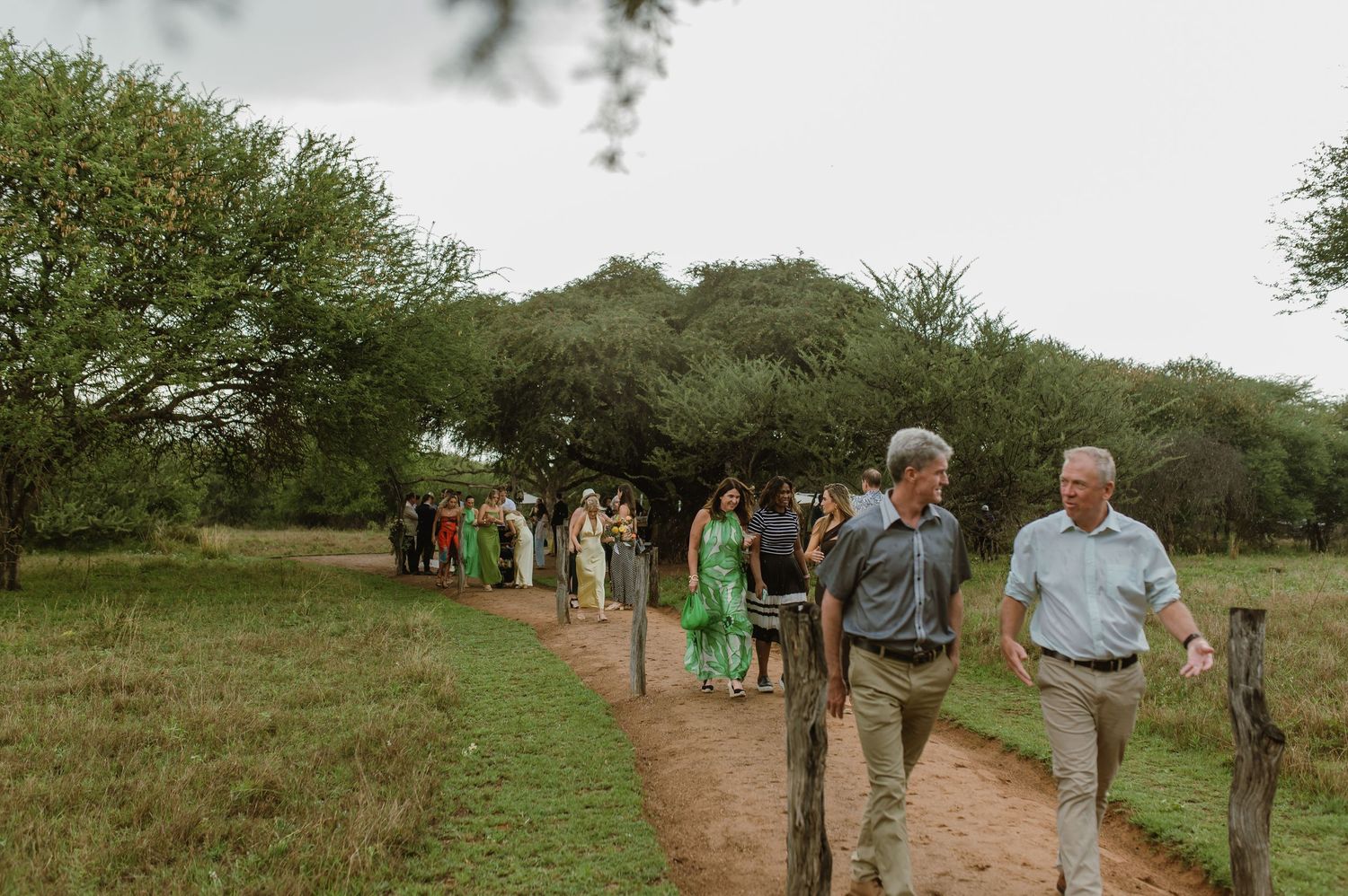 Guests making their way along a natural pathway during an outdoor wedding event.