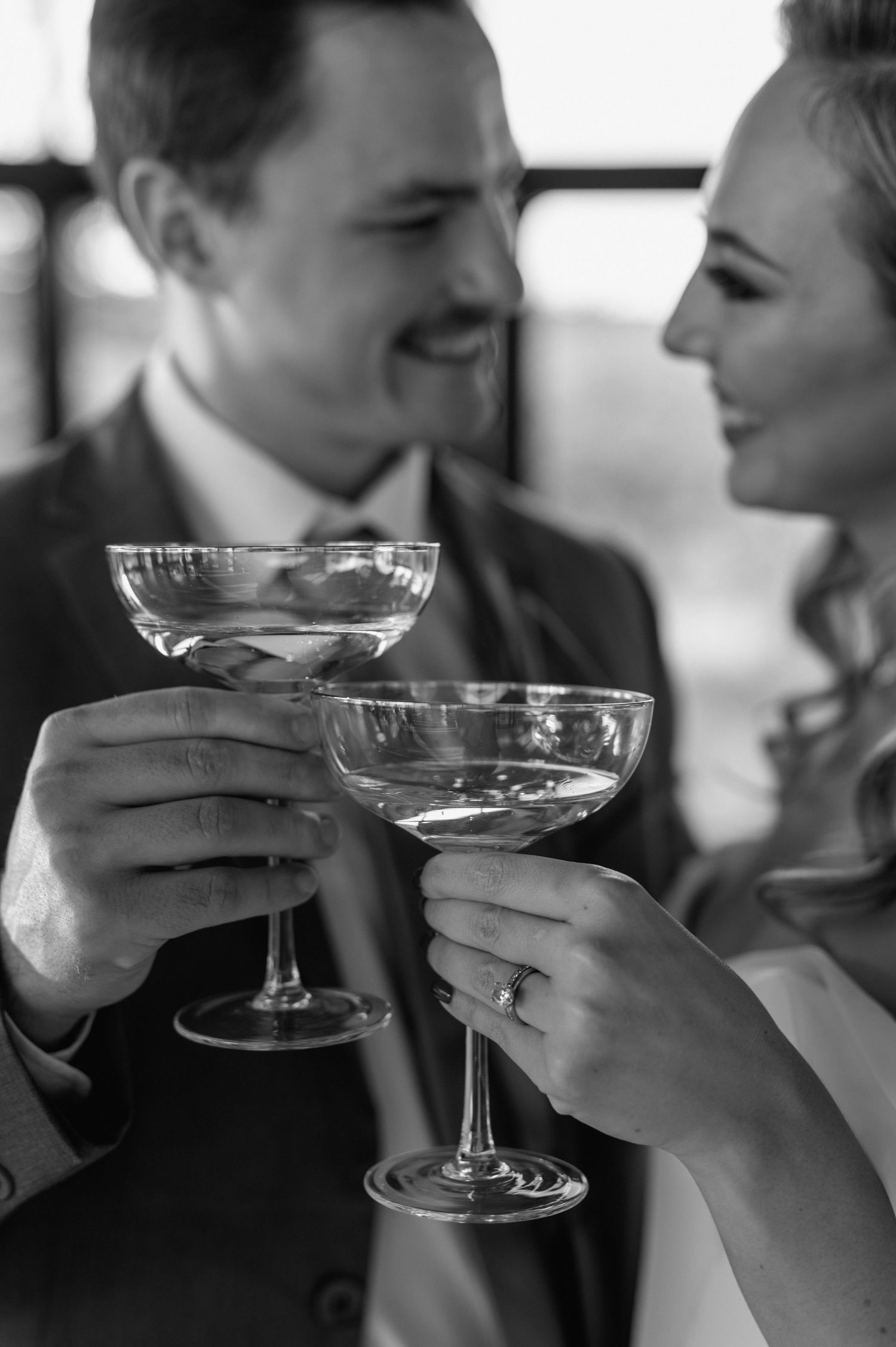 Closeup of champagne glasses toasting during a wedding celebration.
