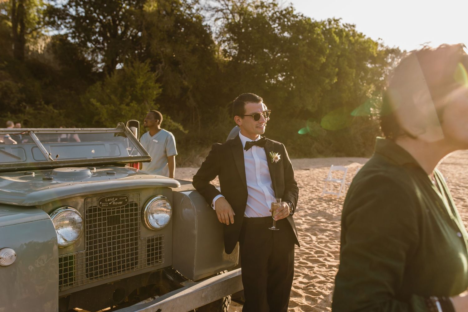 Classic car parked on beach during sunset cocktail reception.