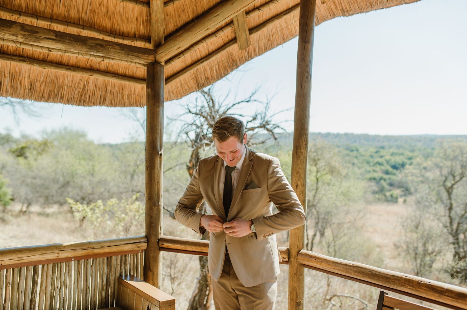 People enjoying a moment on a traditional African lodge deck with panoramic views.