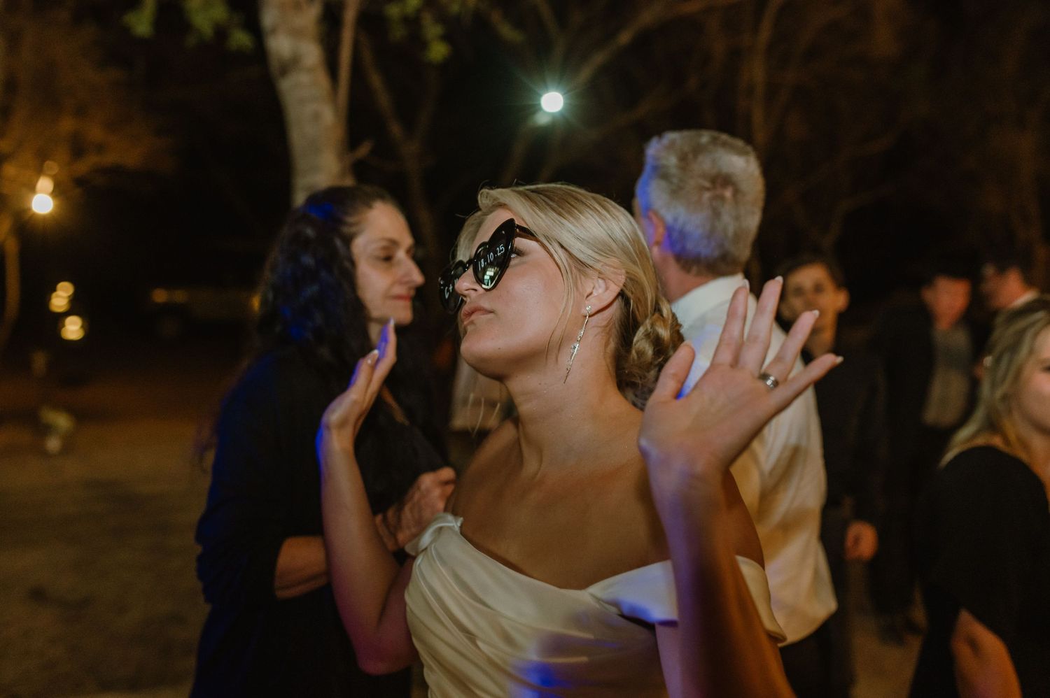 People enjoying a lively nighttime celebration with dramatic lighting and party atmosphere.