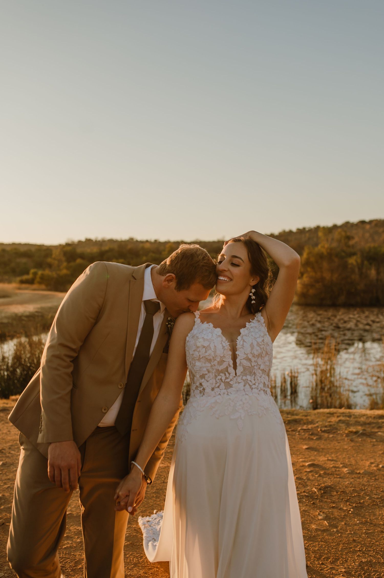 Golden hour wedding portraits with natural landscape and warm sunset lighting.