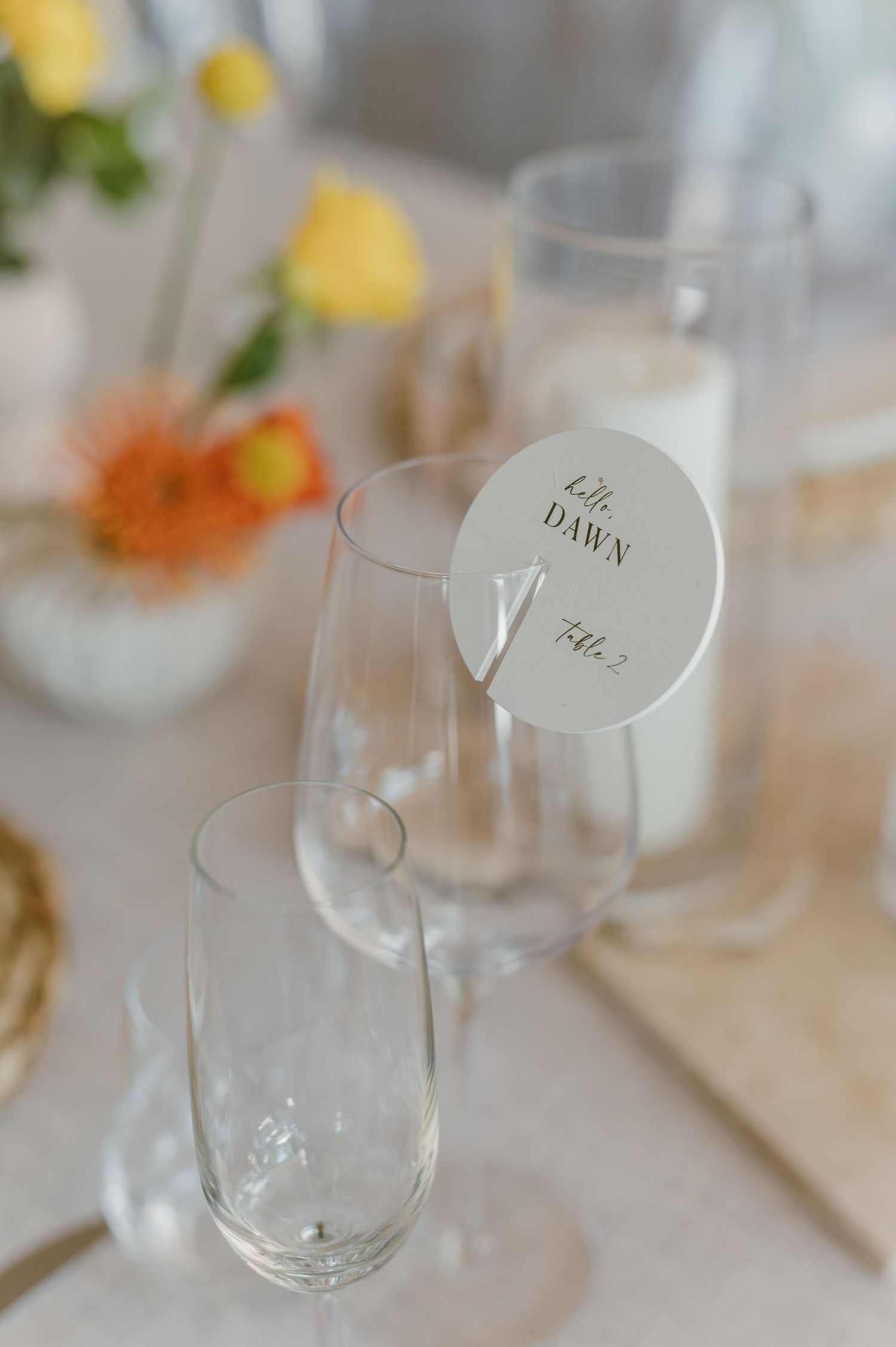 Wedding place setting with wine glasses and name card reading 'til dawn'.