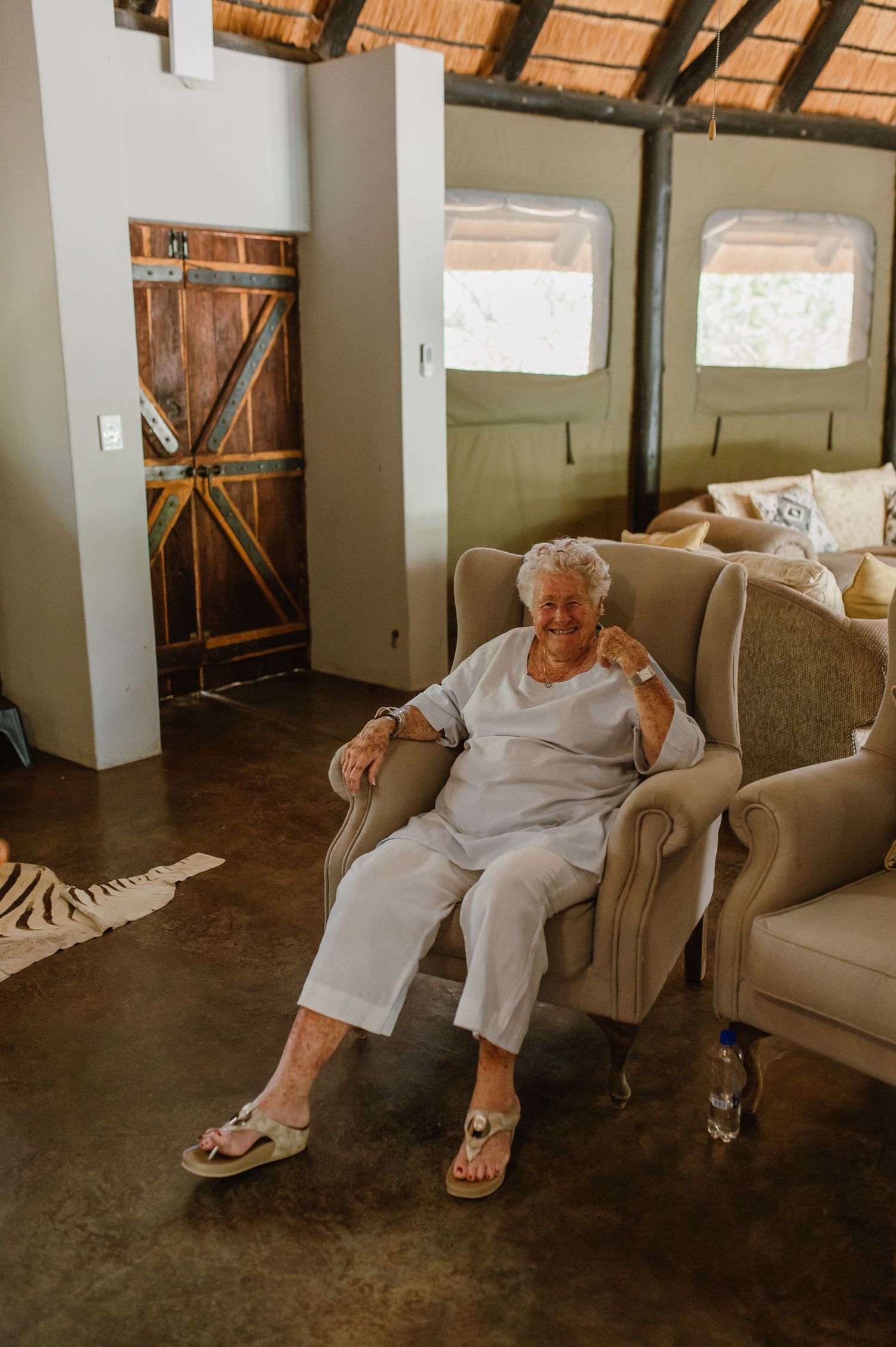 Sequence of relaxed poses in a rustic room with thatched roof and concrete floor.