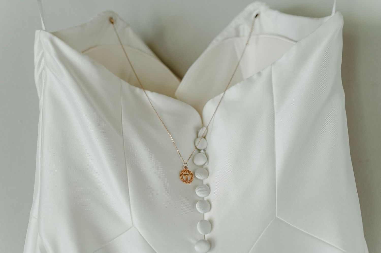 Close-up detail of white wedding dress neckline and buttons.