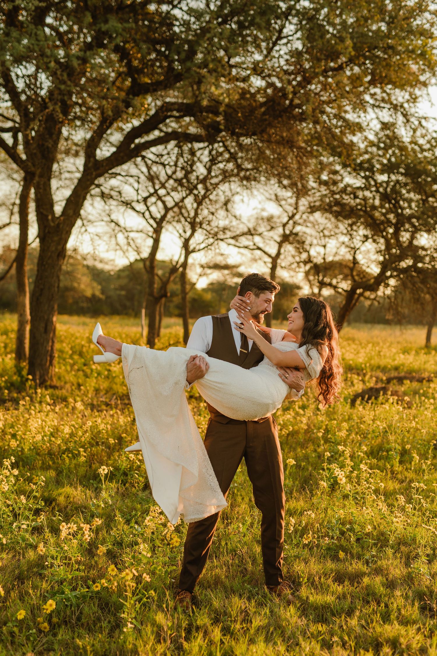 A romantic dance pose in a sunlit meadow with flowing white dress and vintage attire.