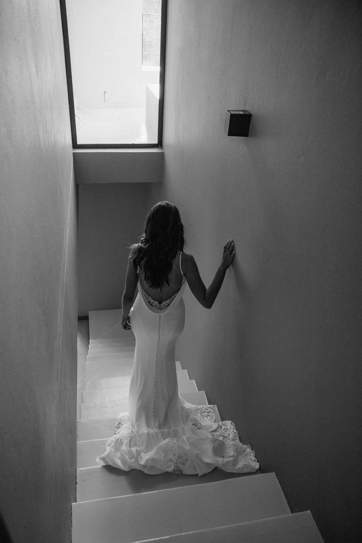 Dramatic black and white photos capture movement on a staircase in an architectural space.