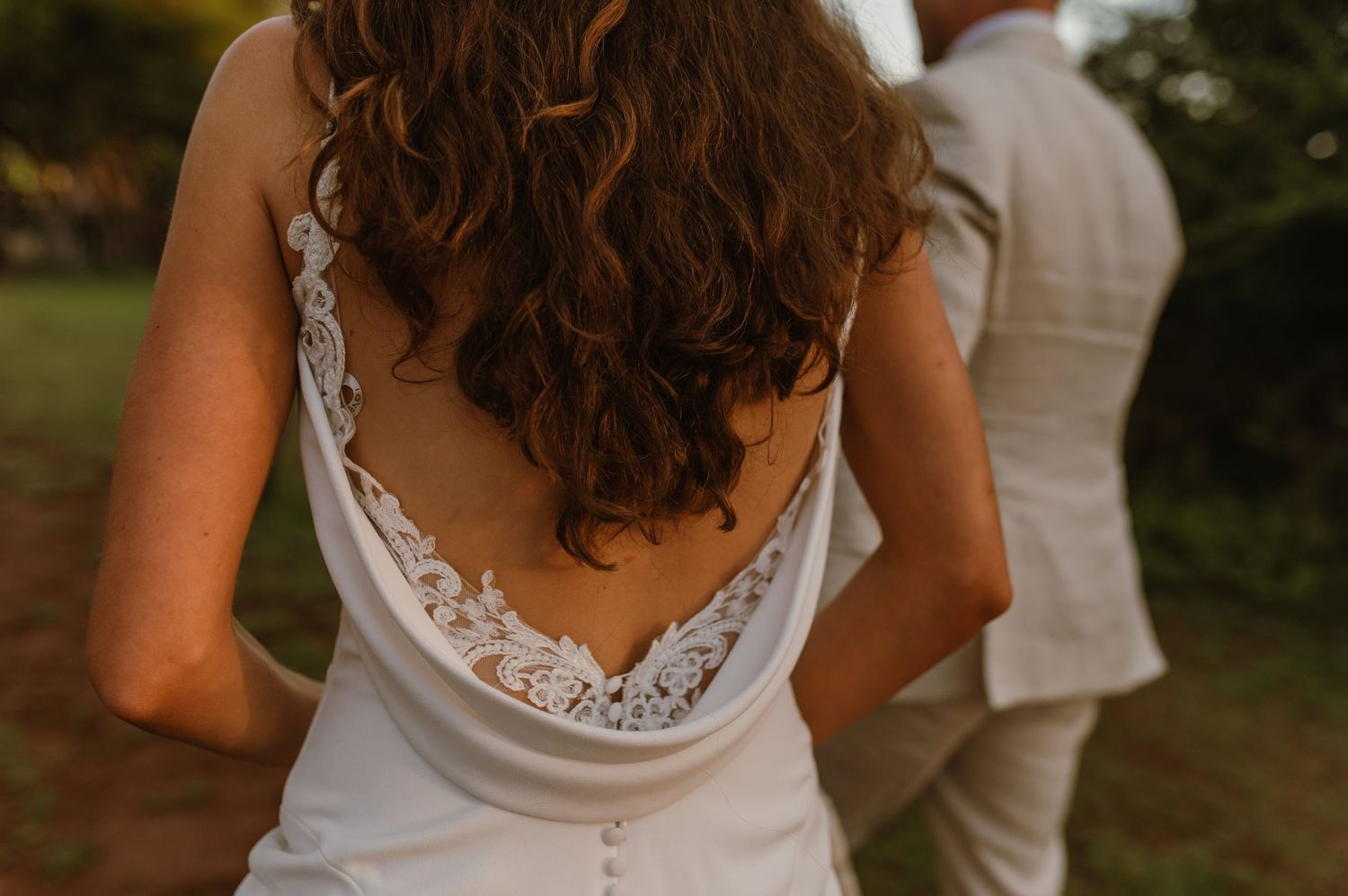 Close-up detail of an elegant white lace wedding dress back with delicate floral patterns.