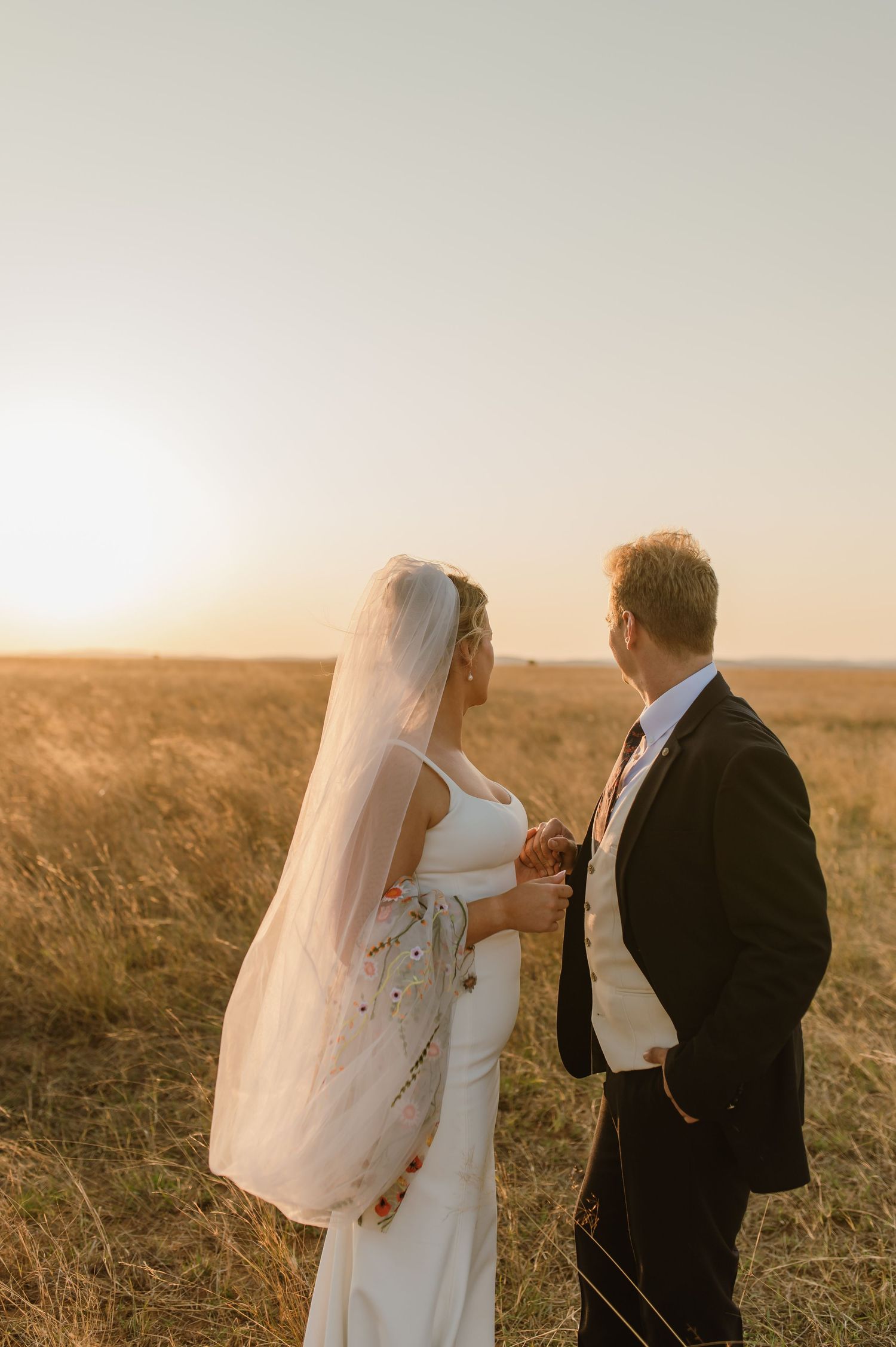Sunset wedding photography capturing romantic moments in golden field.