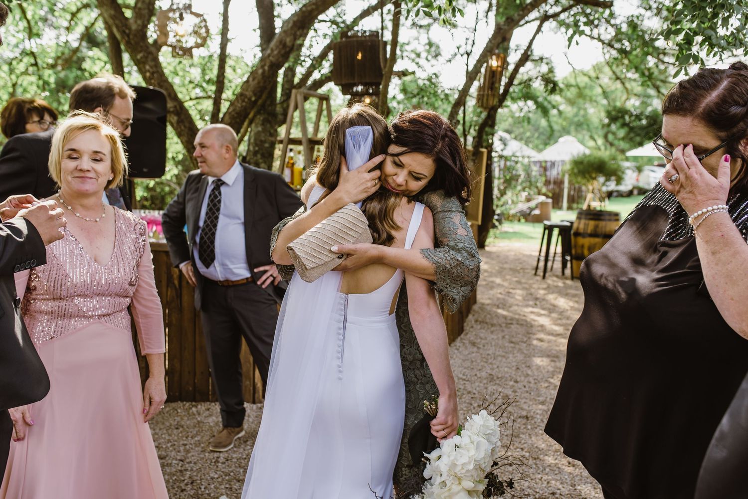 Wedding party and guests celebrate during an outdoor reception.