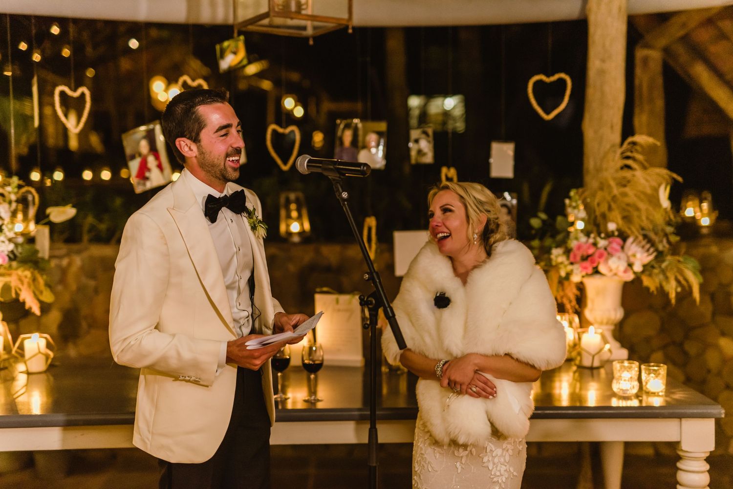 Wedding party celebrating at an elegantly decorated reception with warm lighting and floral details.