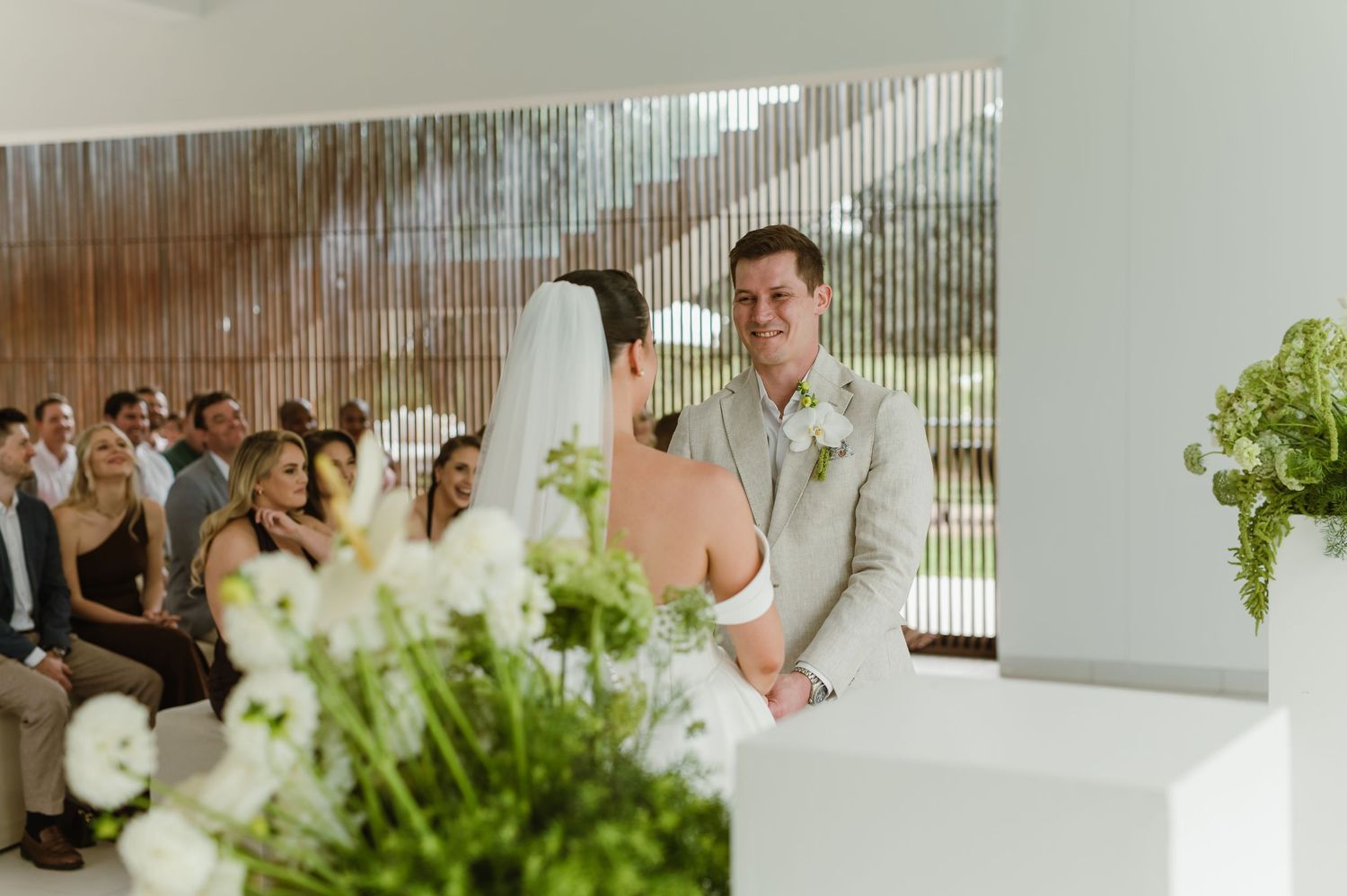 White floral arrangements decorating a modern minimalist wedding reception space.