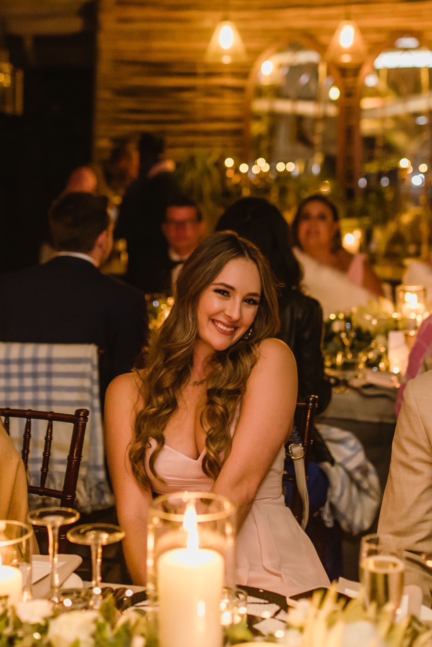 Candlelit wedding reception table with guests enjoying an evening celebration.