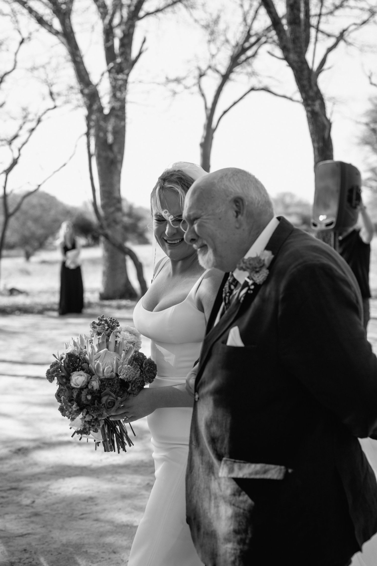 A couple shares an intimate moment during their black and white outdoor wedding photoshoot.
