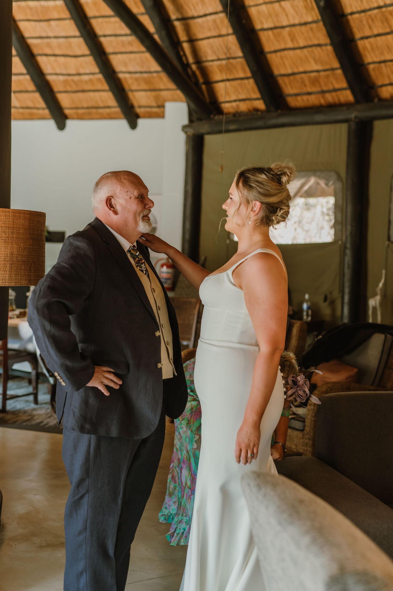 First look moment between couple under a thatched roof venue during wedding preparations.