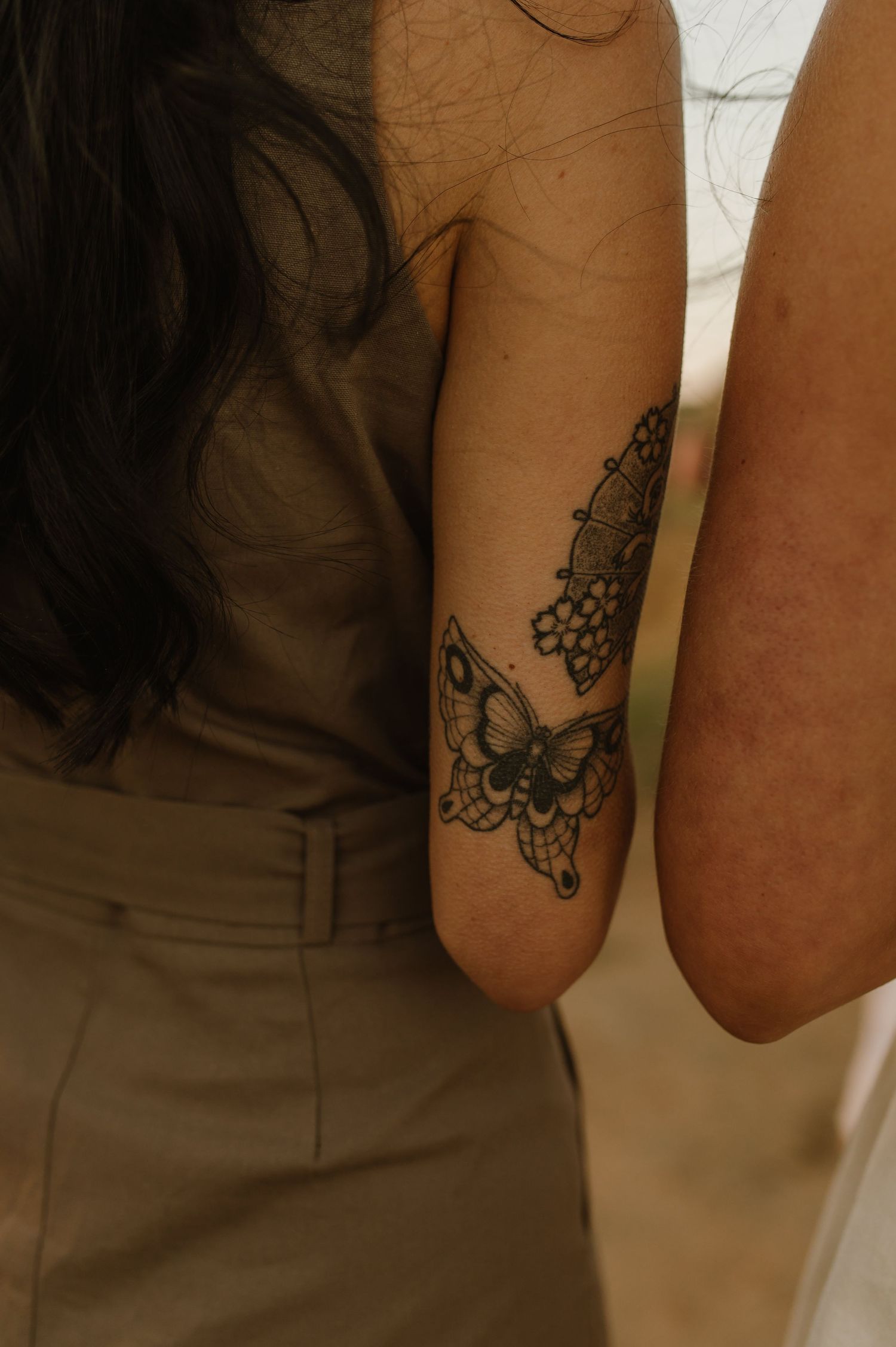 Close-up of a delicate floral tattoo design on someone's arm in black ink.