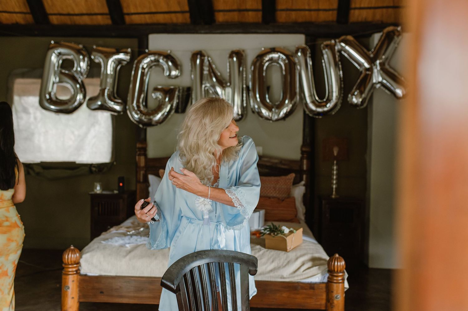 Elegant wedding preparation scene with silver balloon decorations and rustic wooden beams.