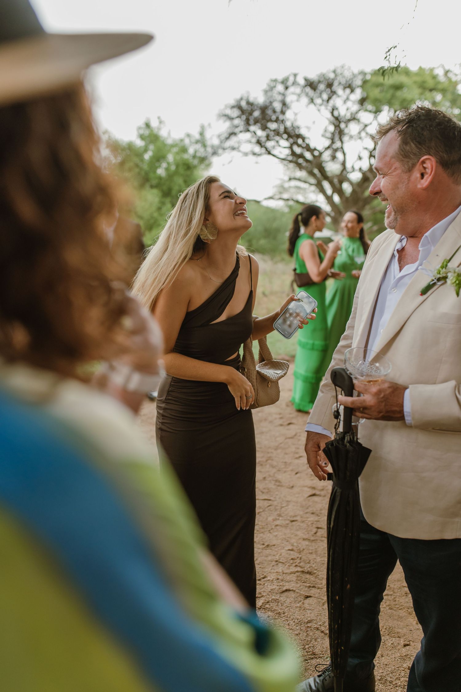 Casual outdoor gathering with guests mingling and holding drinks.