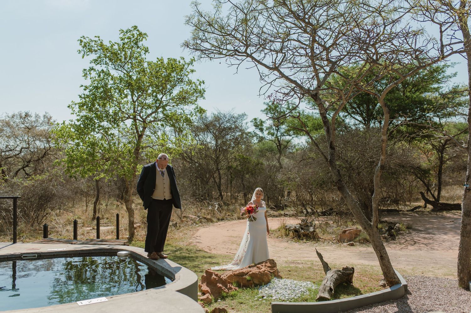 Desert wedding venue with scattered trees and natural landscape.