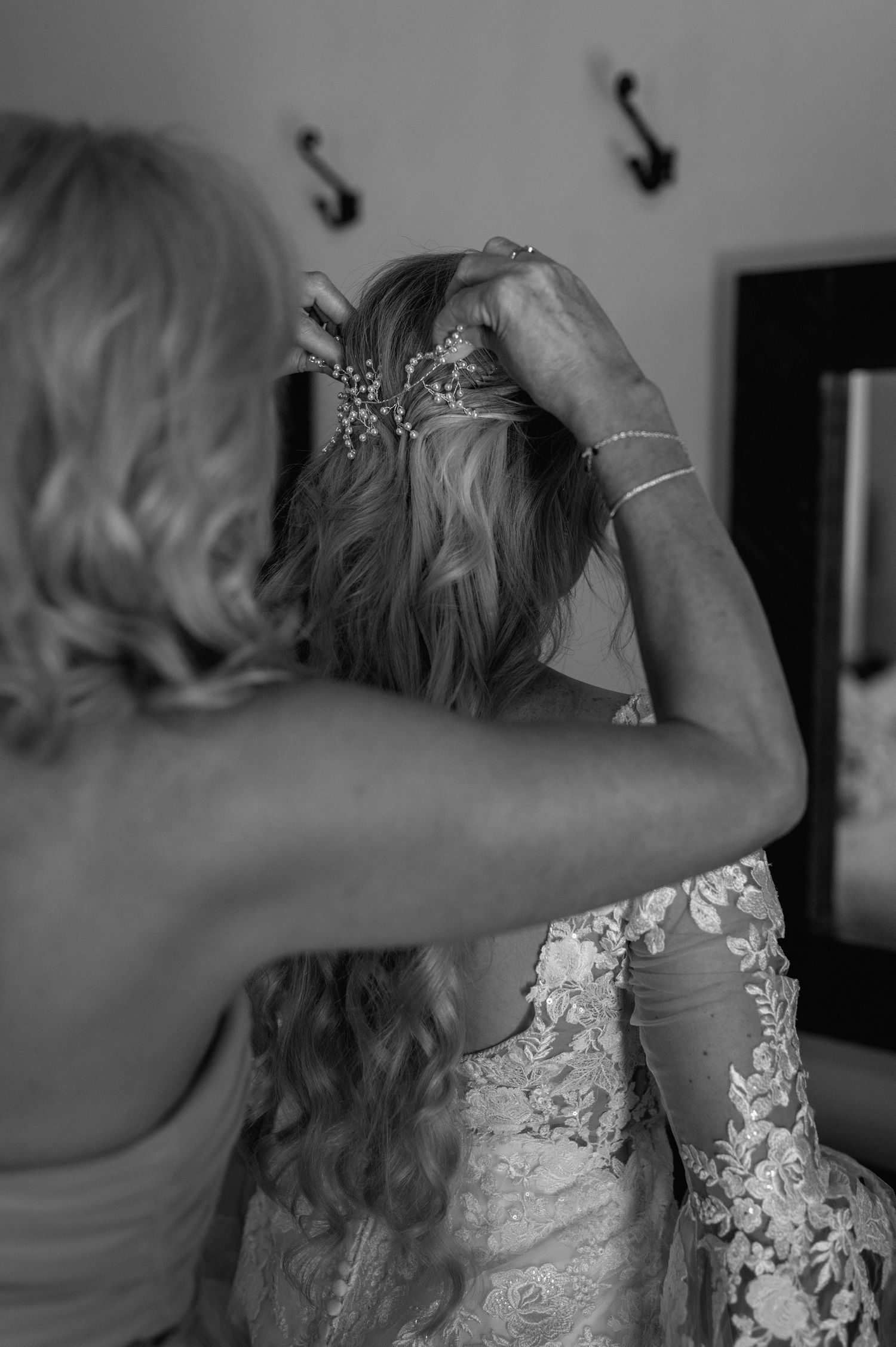 Black and white image of final hair styling preparations on wedding day.