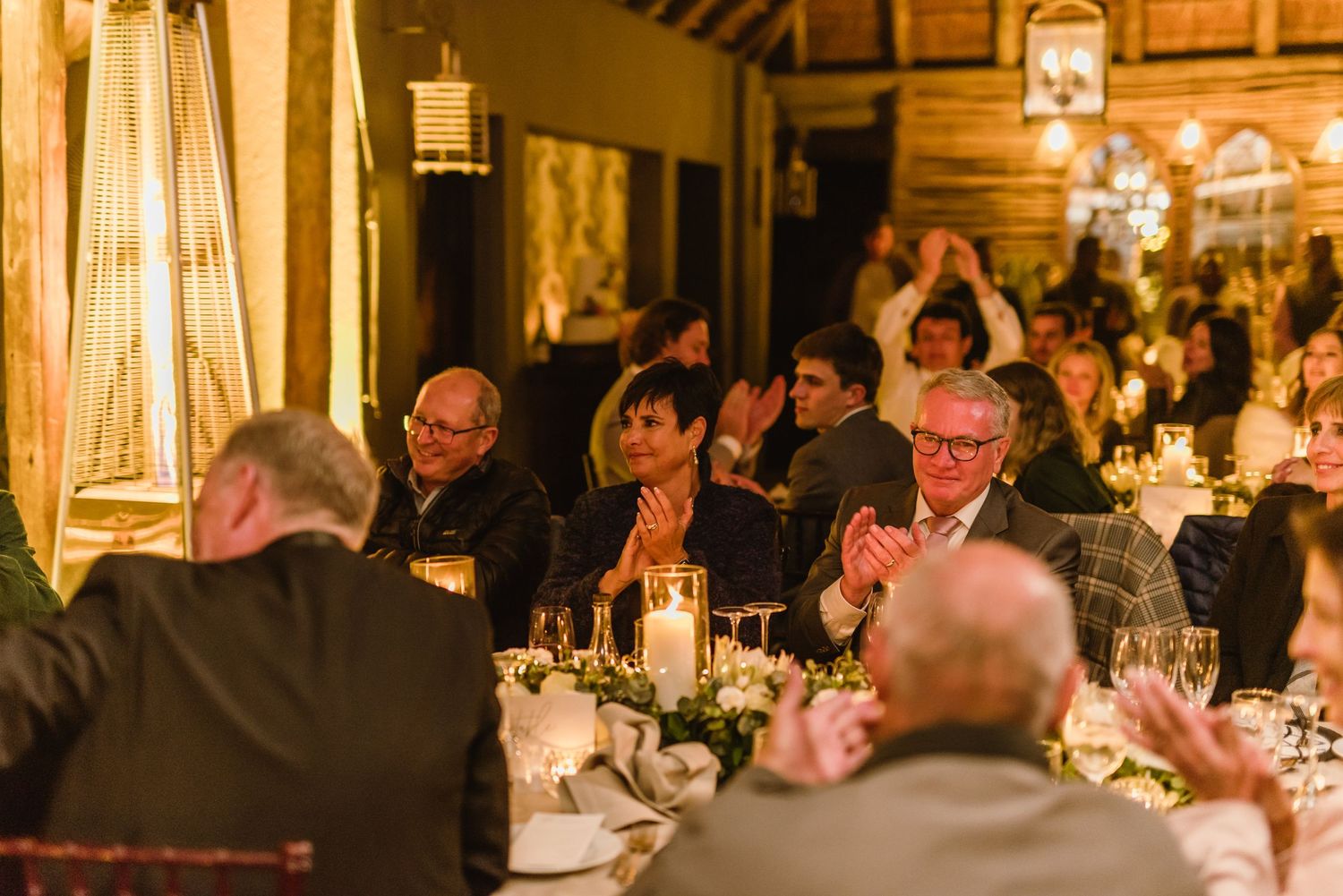Wedding celebration featuring long dining tables with elegant place settings and ambient lighting.
