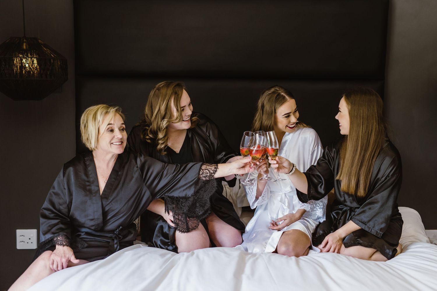Wedding party getting ready scene with bridesmaids in matching robes.