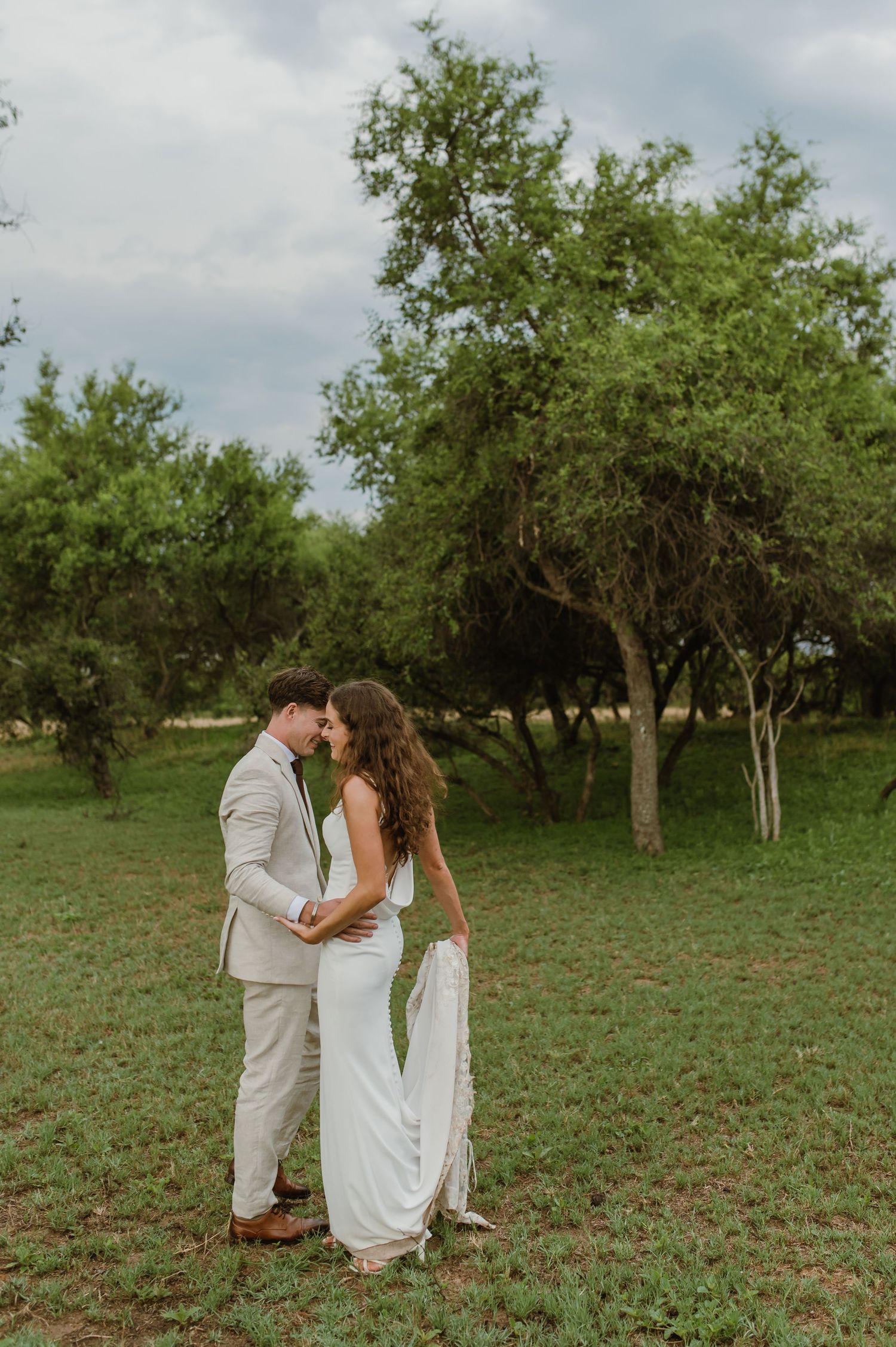 Tender wedding moments captured in a green orchard setting.