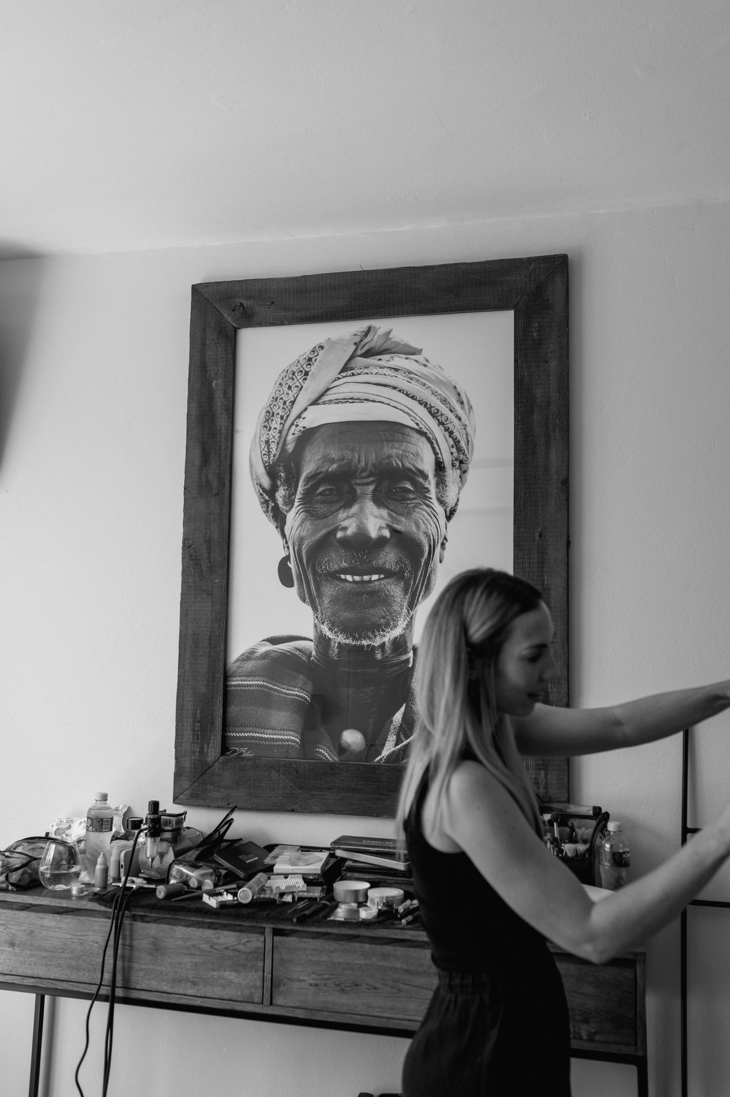 Black and white portrait photography displayed on wall with person viewing.