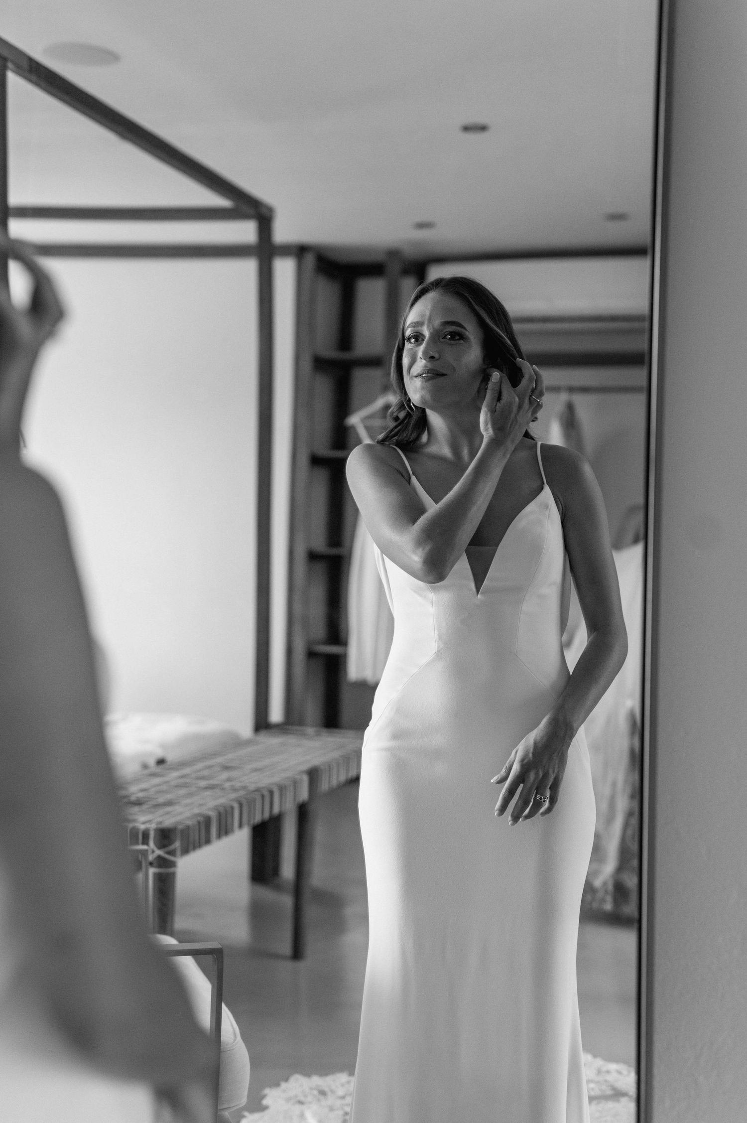 Black and white portrait of a bride getting ready in an elegant fitted dress.
