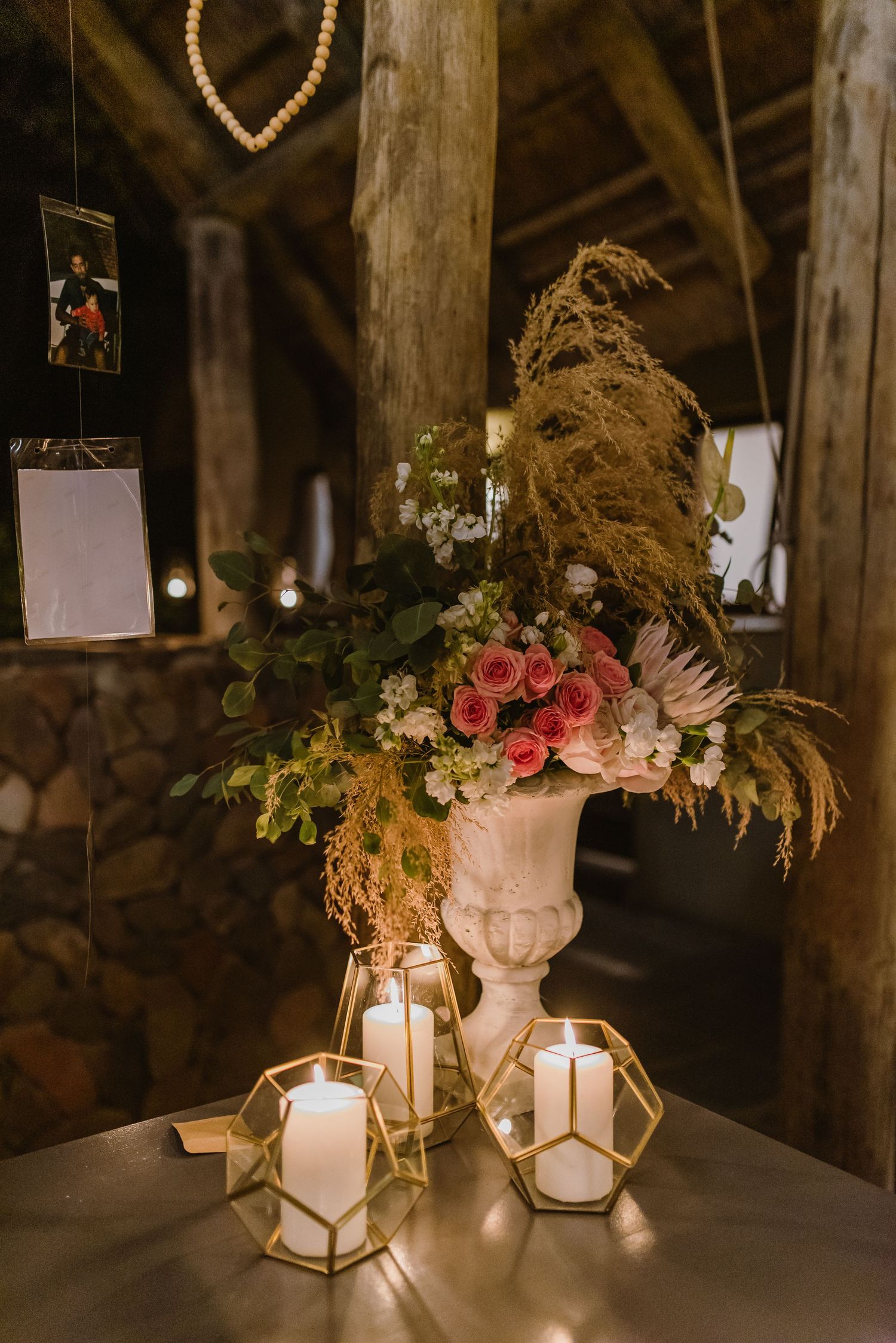 Geometric lanterns with floral arrangements and candles create romantic wedding decor.