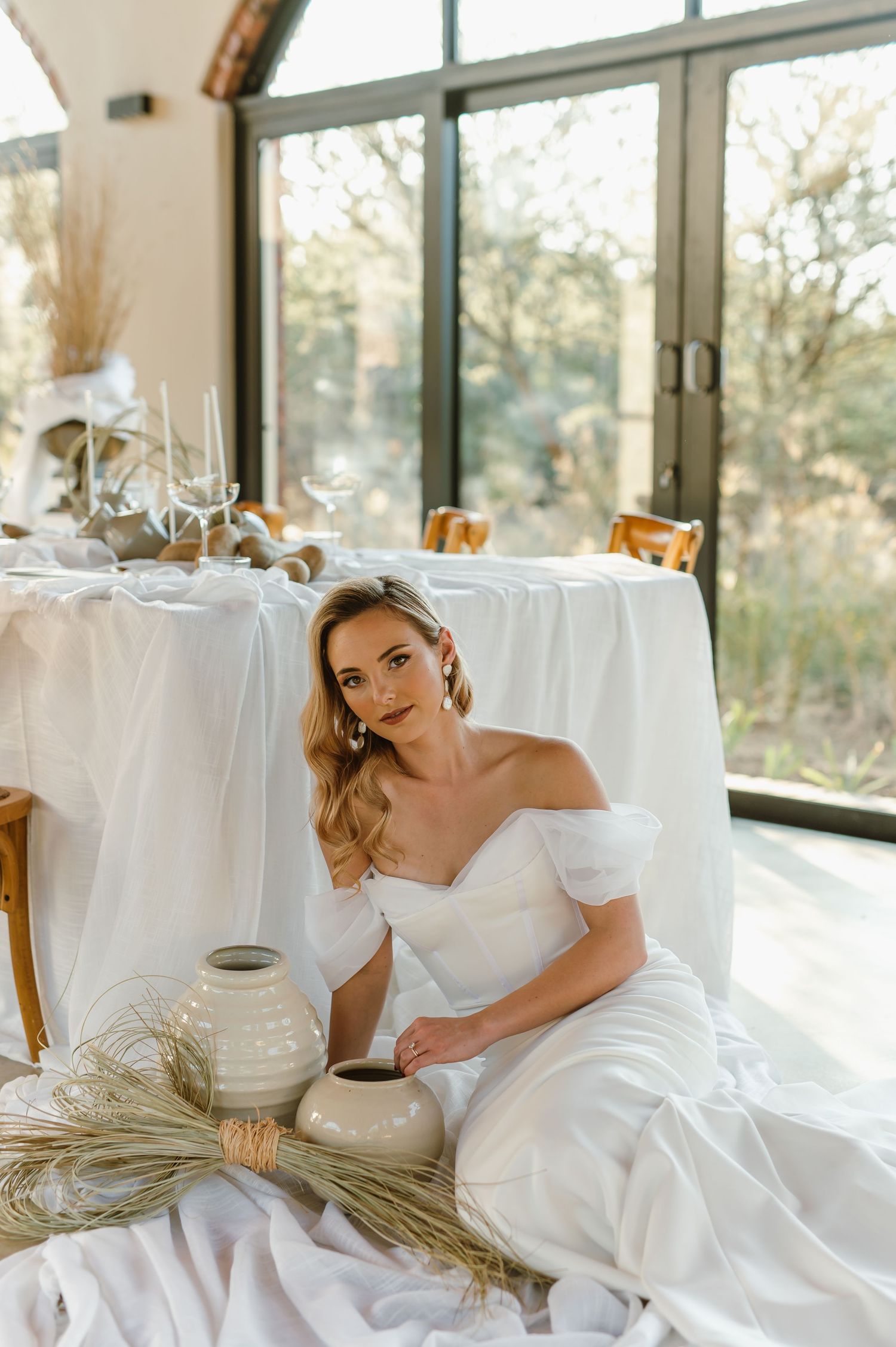 Bright sunlit venue interior with white linens and natural decor elements.