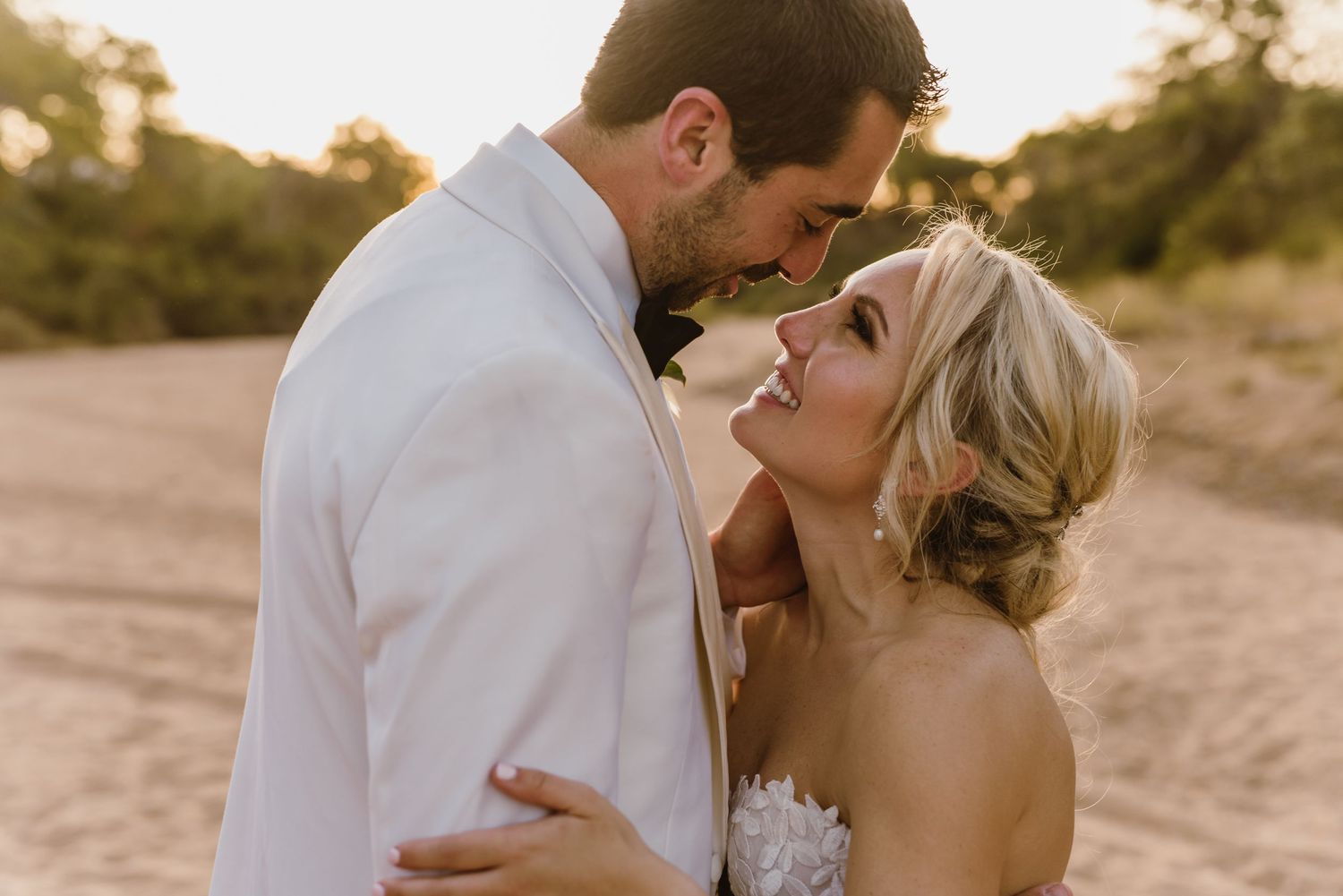 Intimate wedding portraits captured on sandy beach at sunset.
