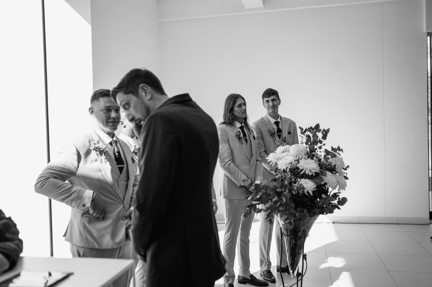 Black and white candid moments from an indoor wedding ceremony with natural light.