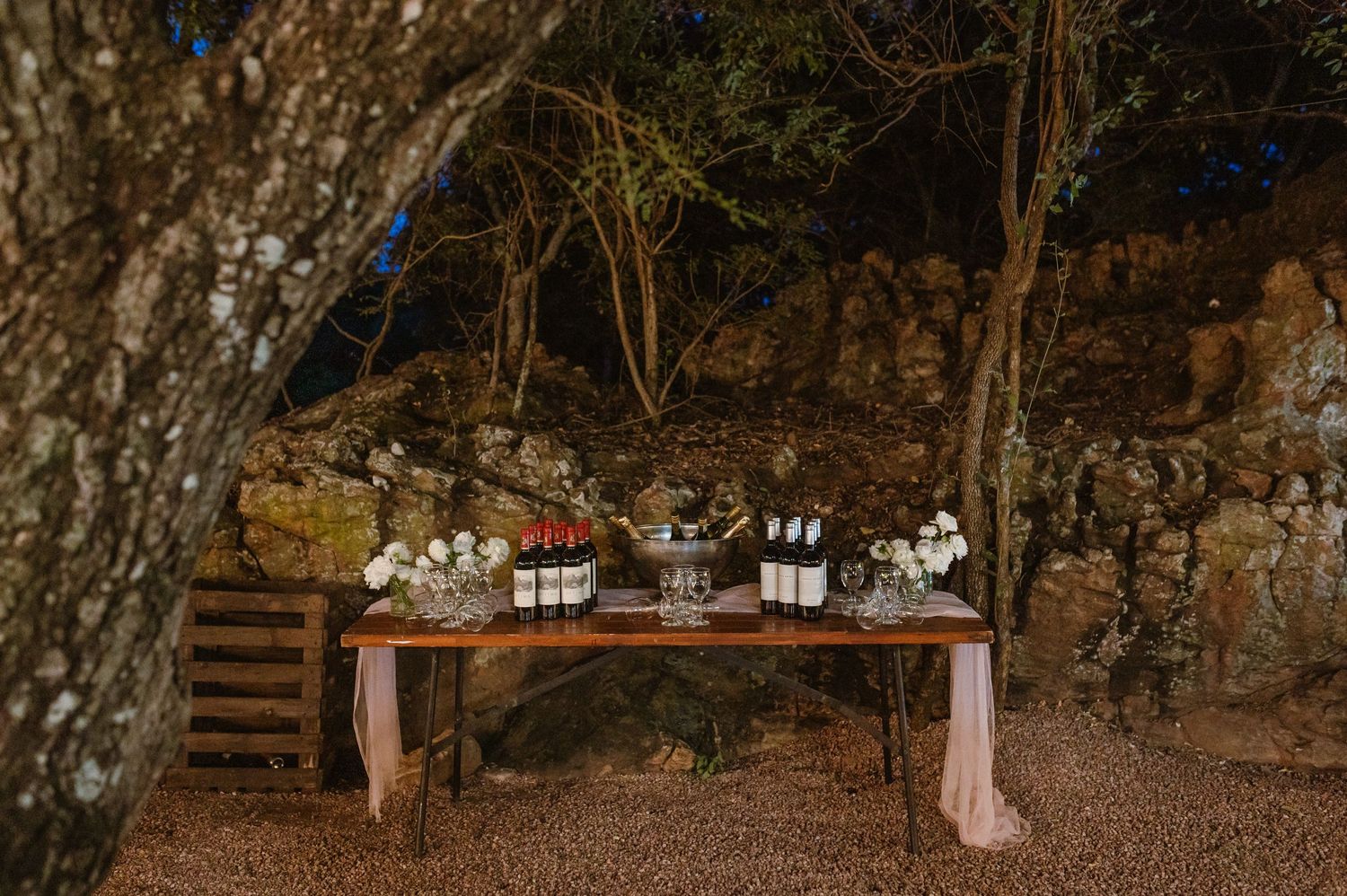 Natural woodland setting with rustic decor elements and ambient lighting for an outdoor event.