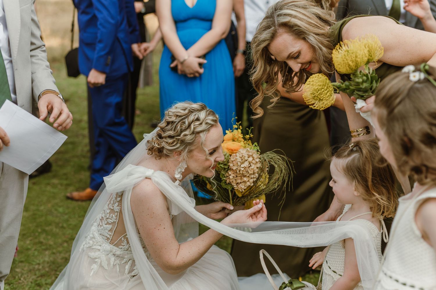 Wedding guests signing a guestbook at an outdoor celebration.