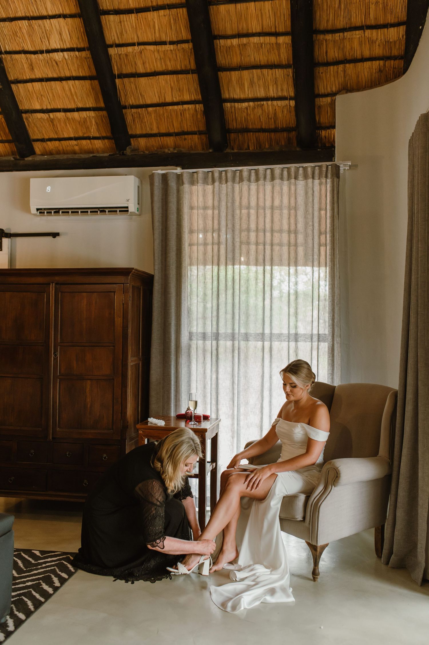Interior of luxury safari lodge room with thatched roof and elegant furniture.