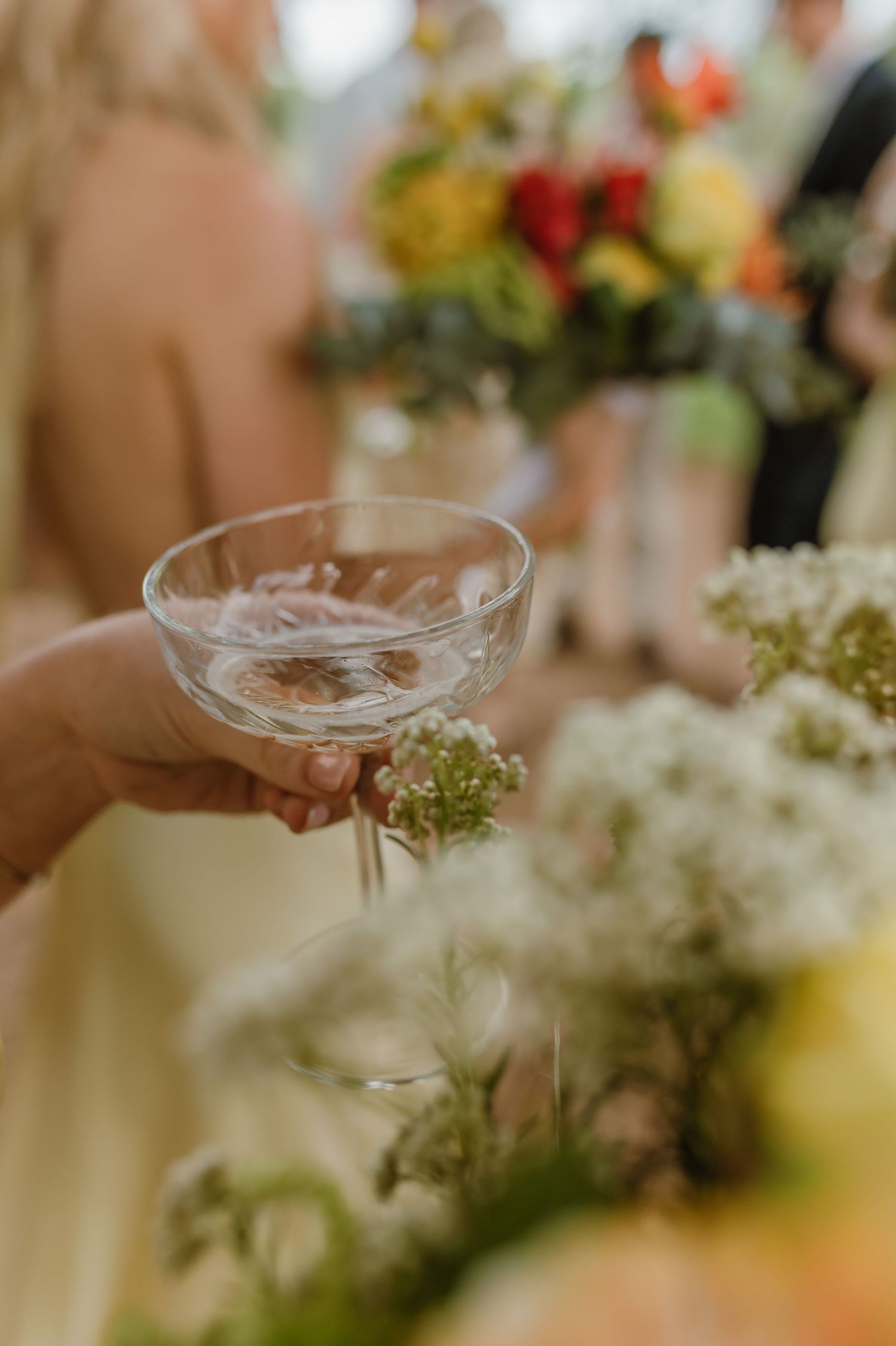 Elegant champagne glasses and floral centerpieces on wedding reception tables.