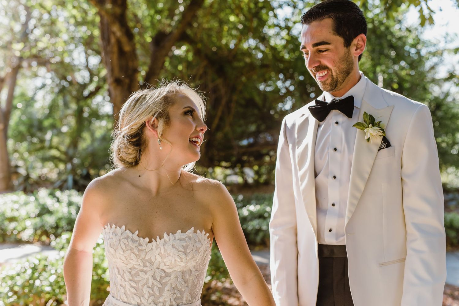 A bride and groom share a joyful moment together during their outdoor wedding ceremony.