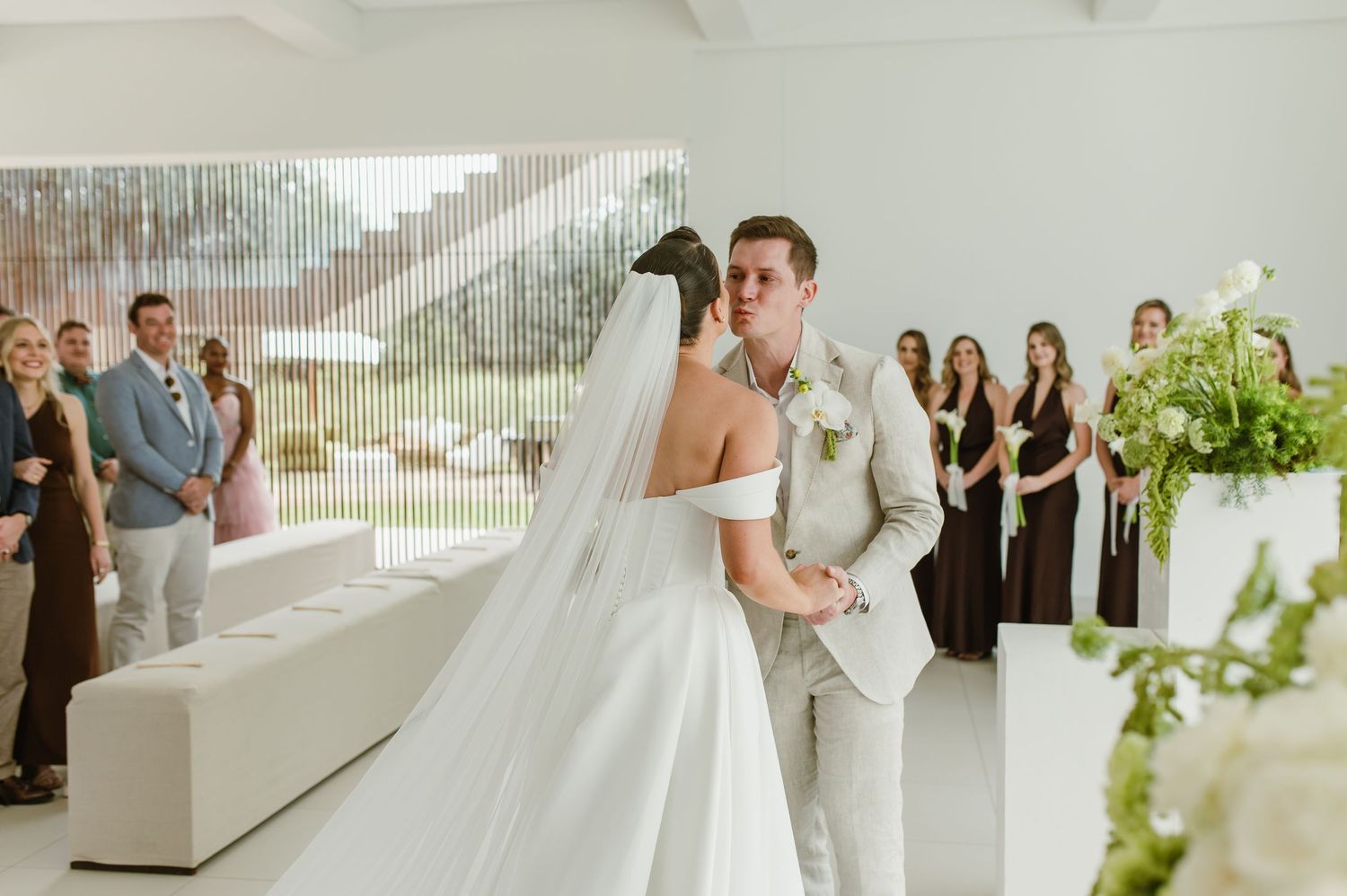Modern wedding ceremony in a bright white venue with minimalist decor and natural light.