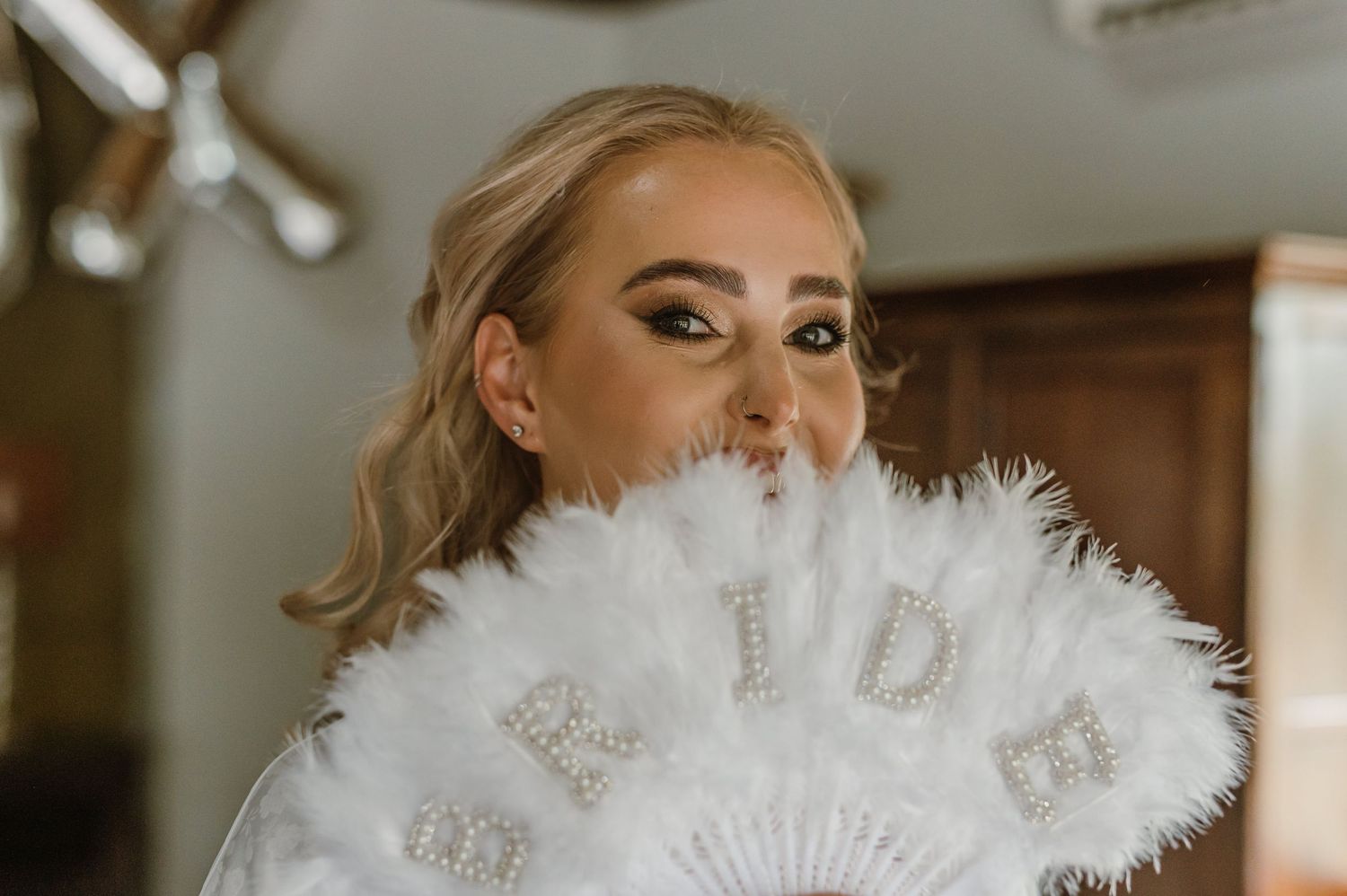 Wedding preparation scene with decorative white fan and elegant styling.