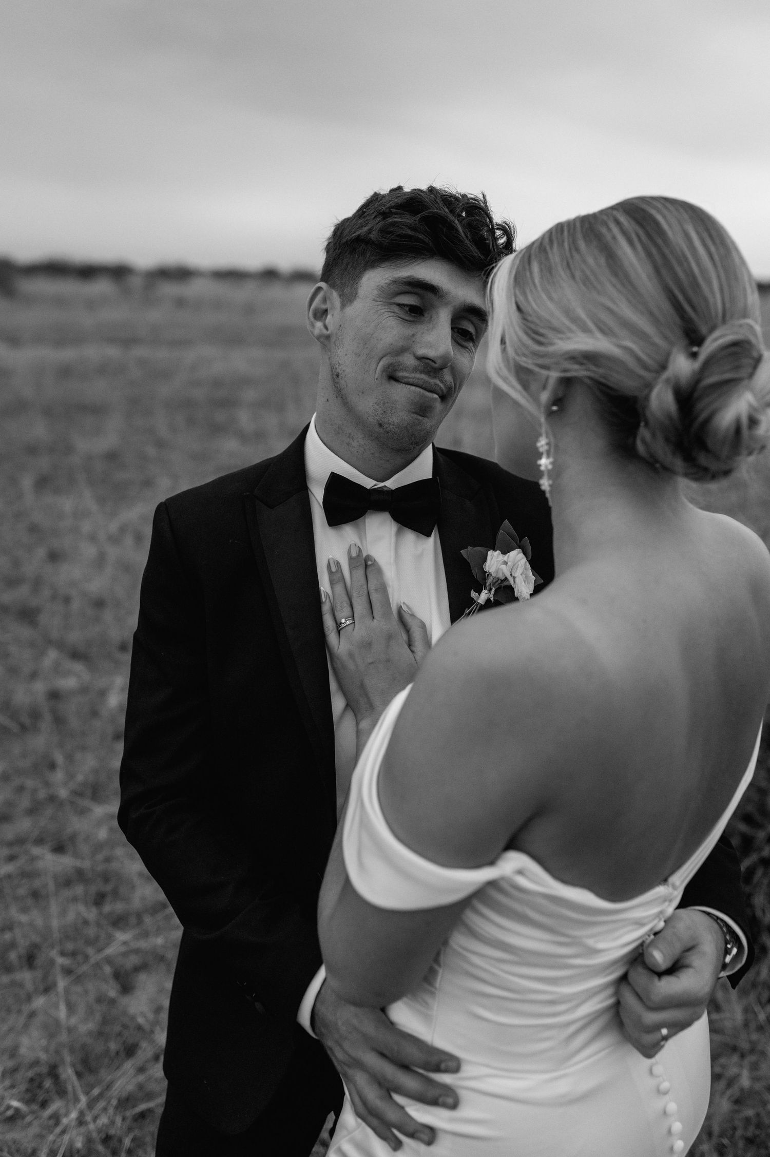 Candid wedding moment shows couple's natural chemistry in outdoor setting.