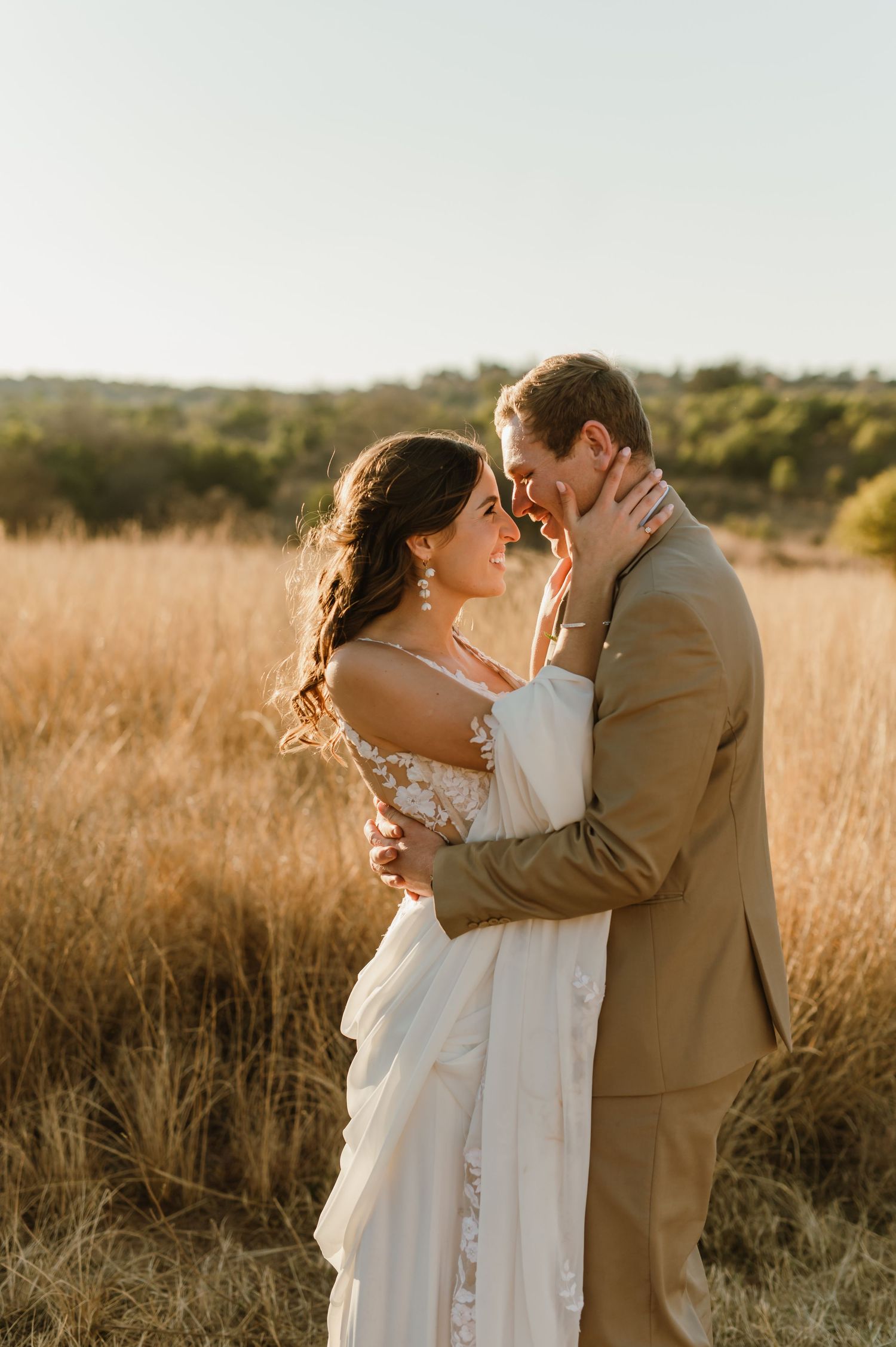 Romantic sunset wedding portraits in a golden grass field.